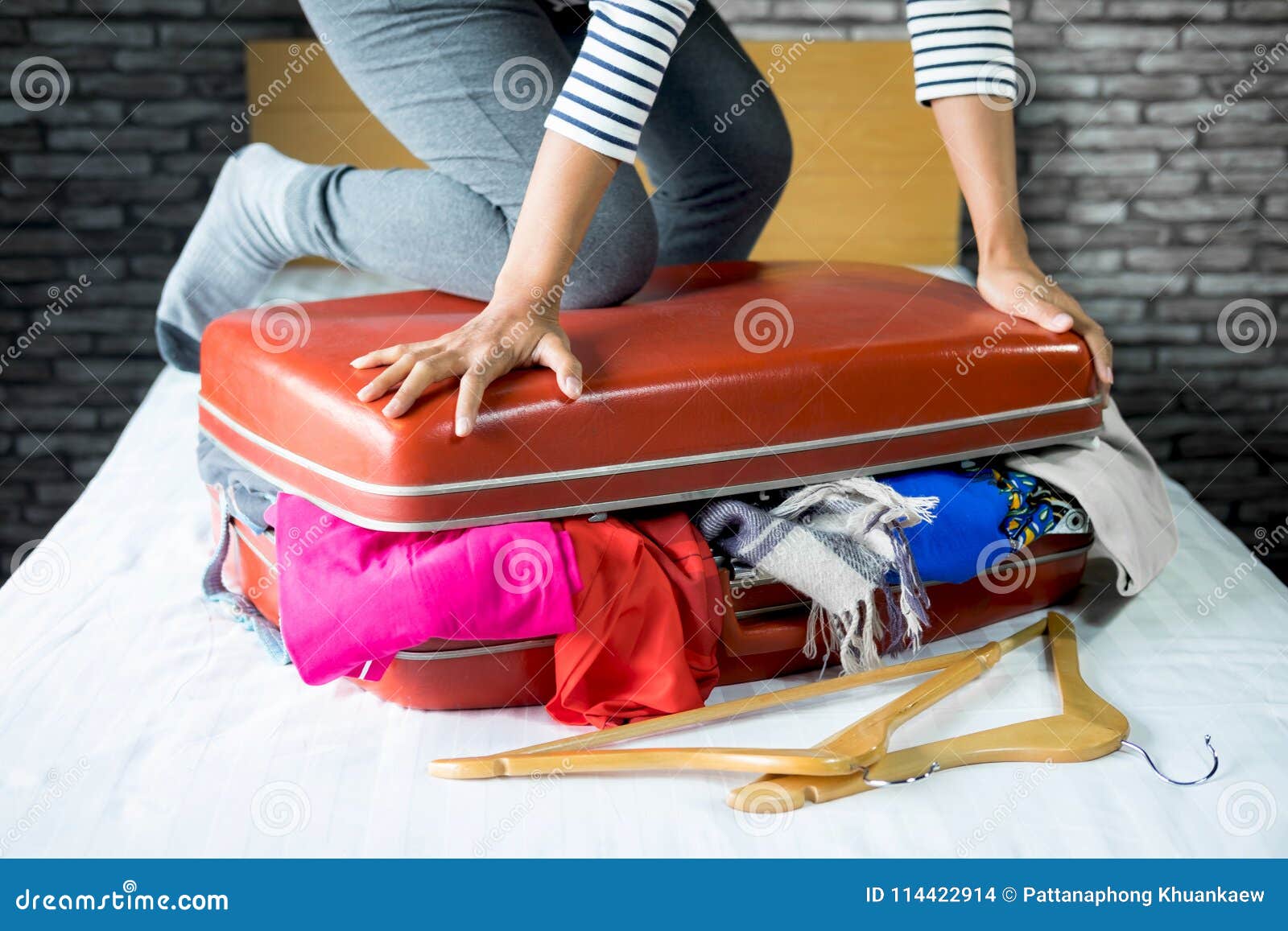 Young woman packing luggage in bedroom at home stock photo