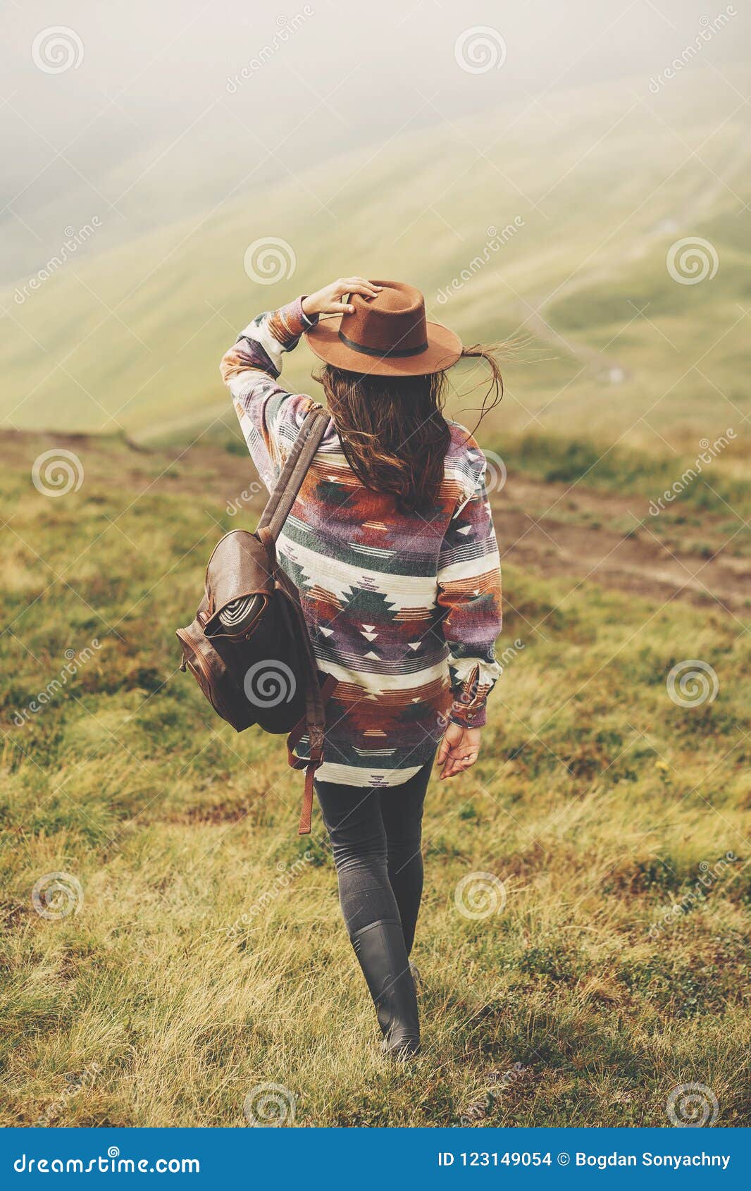 travel and wanderlust concept. stylish traveler girl holding hat