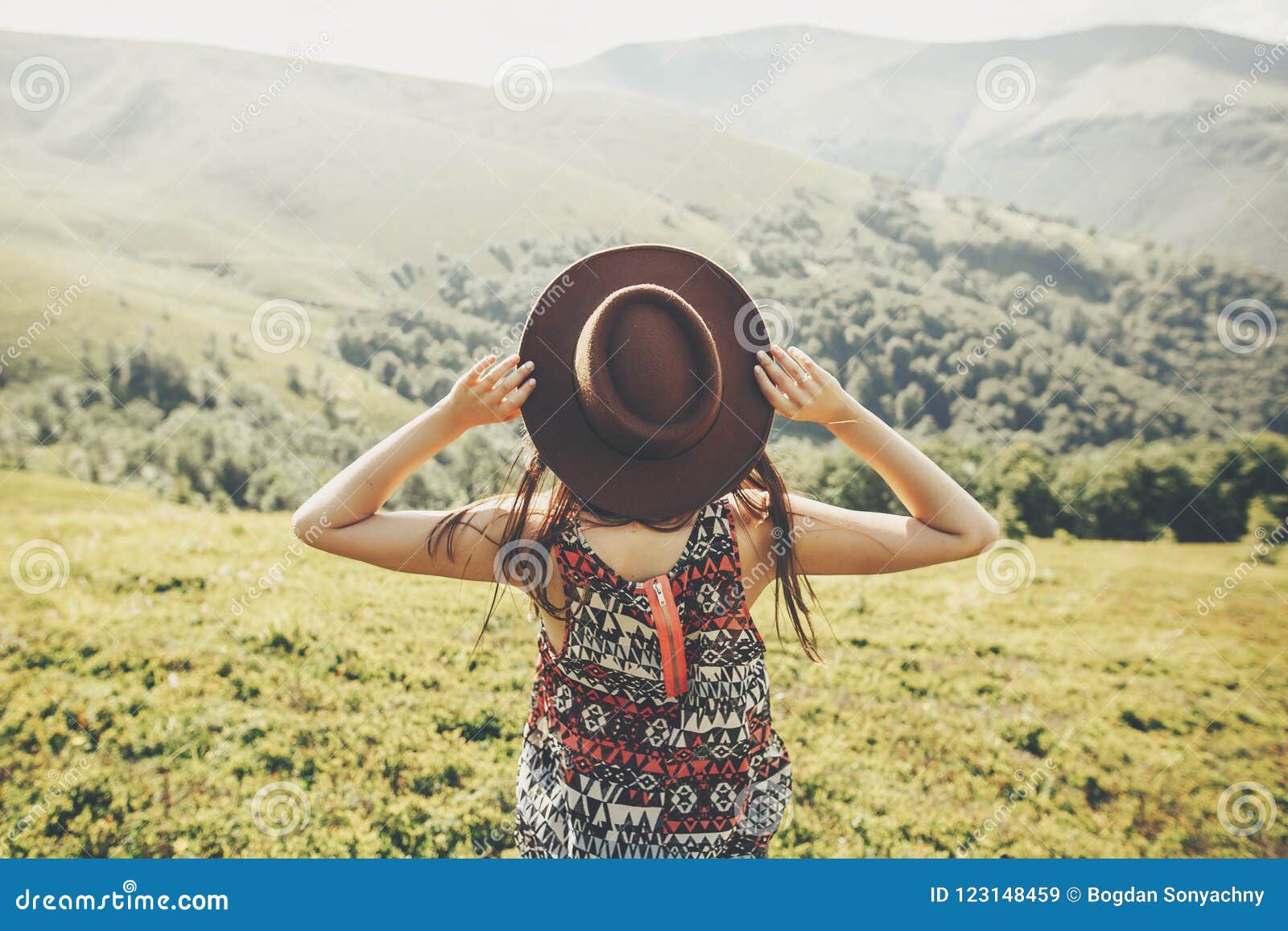 travel and wanderlust concept. traveler hipster girl holding hat