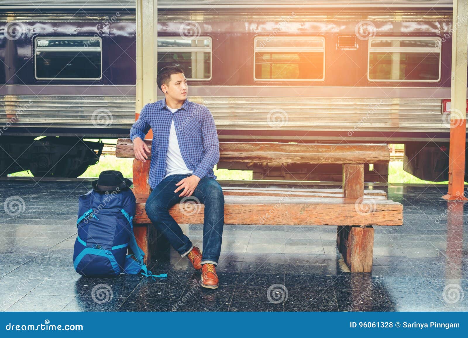 traveler man waits train on railway platform
