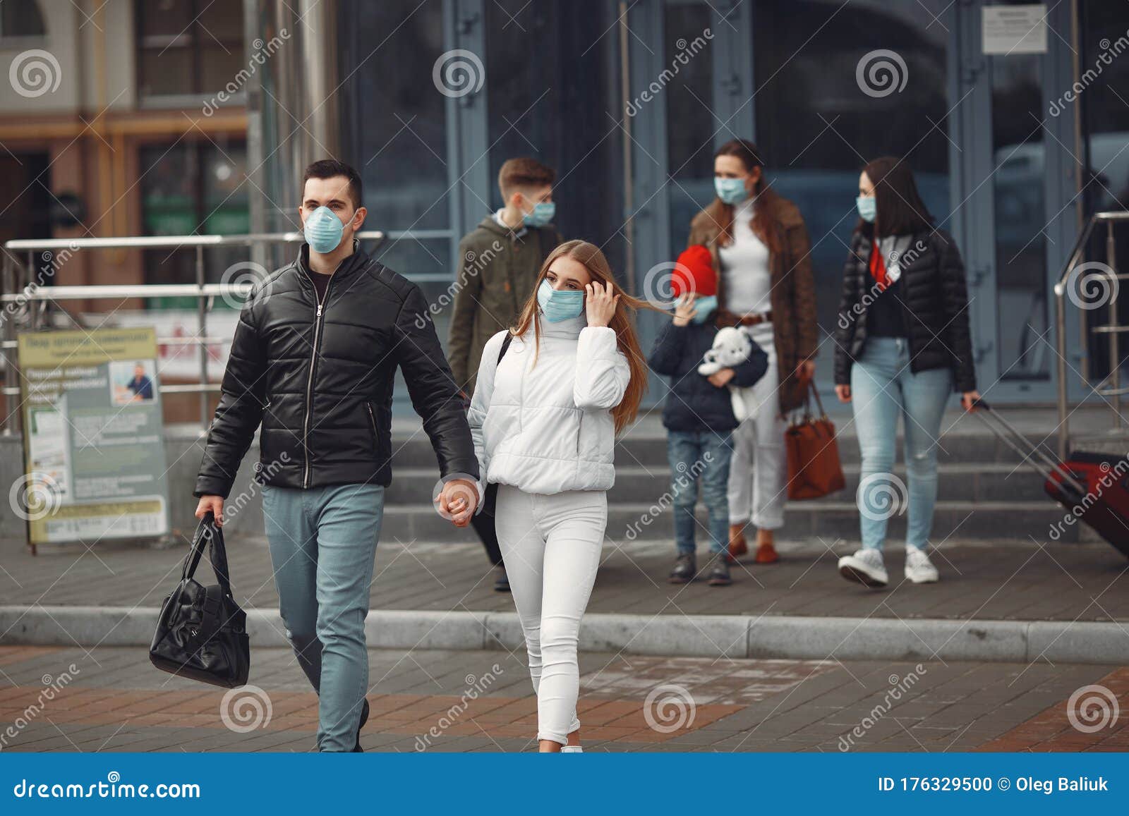 travelers leaving airport are wearing protective masks