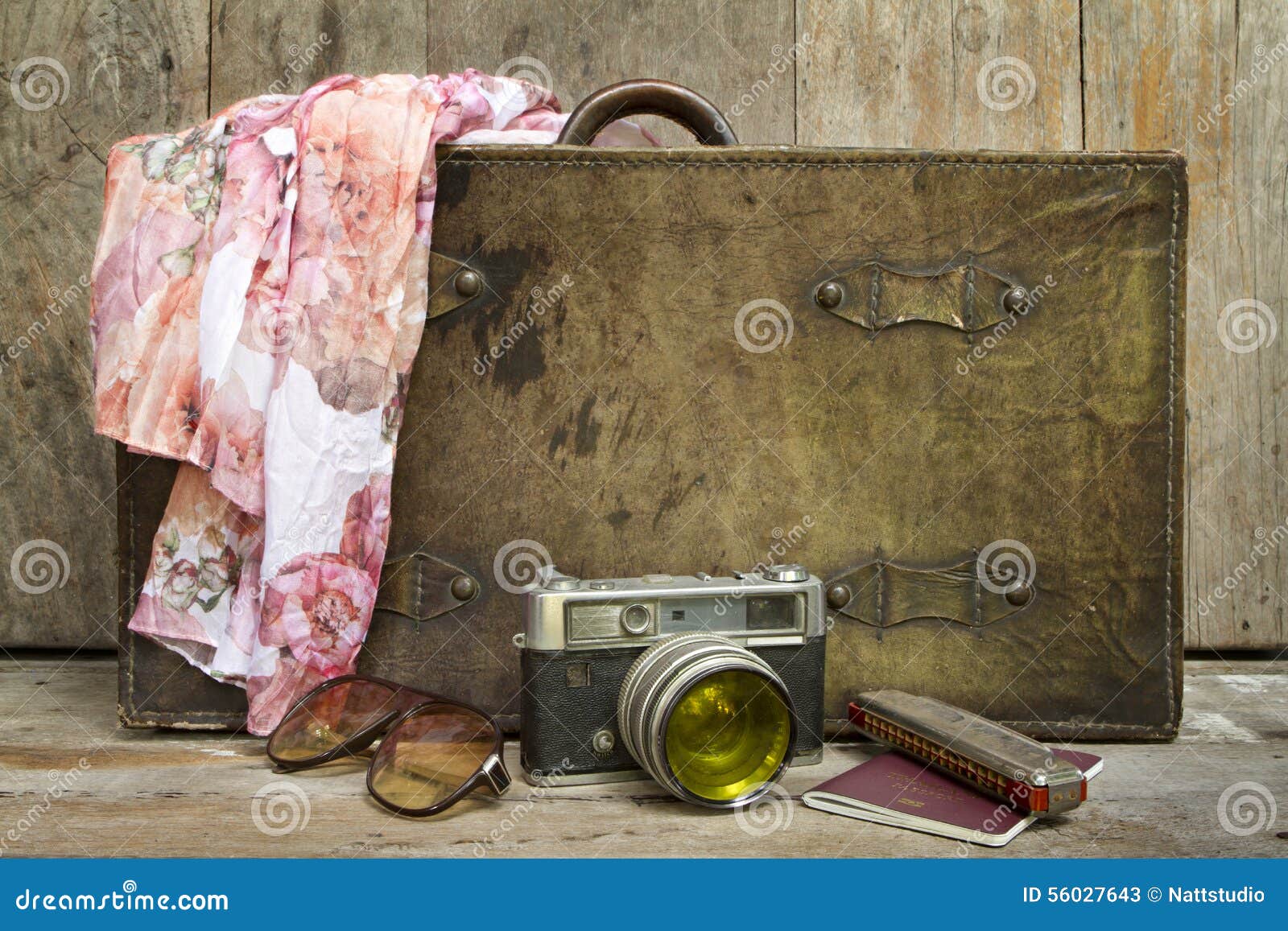 traveling concept of retro consists suitcase, camera, sunglasses, mouth organ, shawl and on wooden background