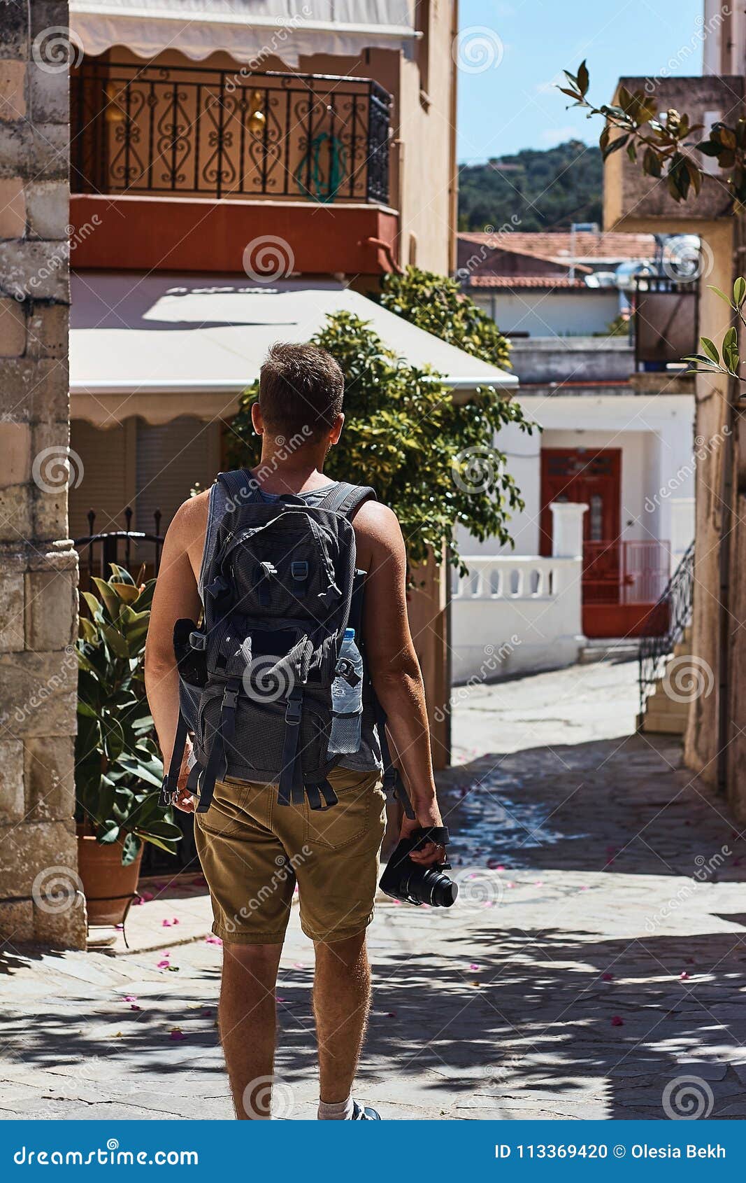 Traveller with Camera and Backpack Walking through the Foreign City