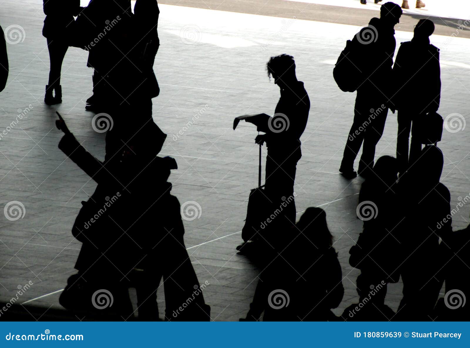 travellers silhouetted on station concourse