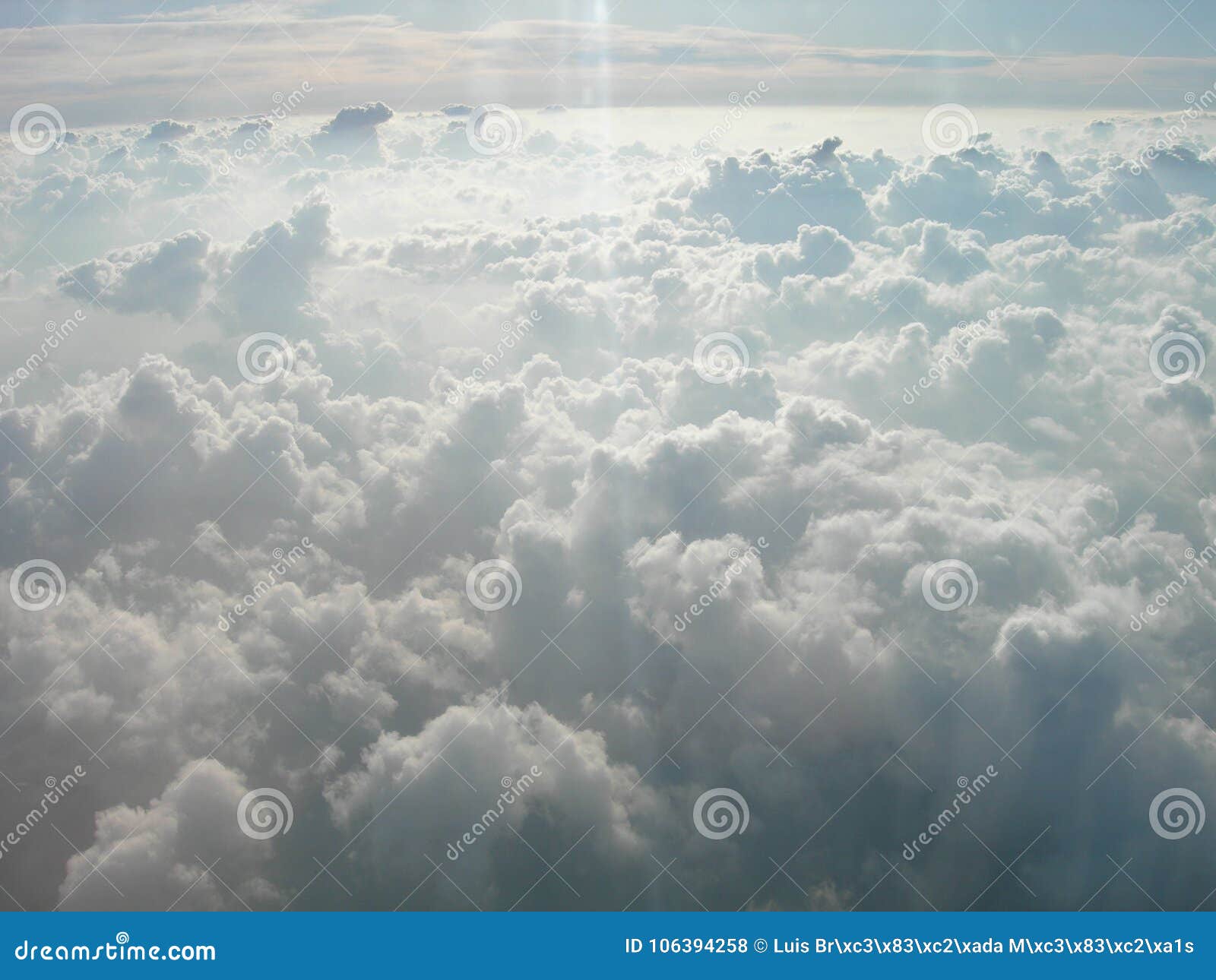 travelling trough fields of white clouds in the sky. light ray in the sky. rayo de luz sobre las nubes