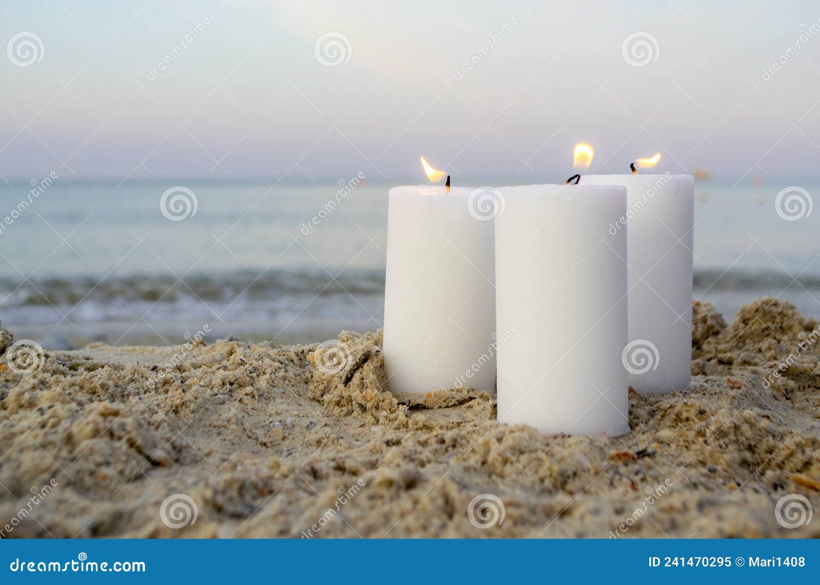 Tre Grandi Candele Di Paraffina Bianca Bruciano Su Fondo Mare Di Sabbia  Immagine Stock - Immagine di notte, ardente: 241470295