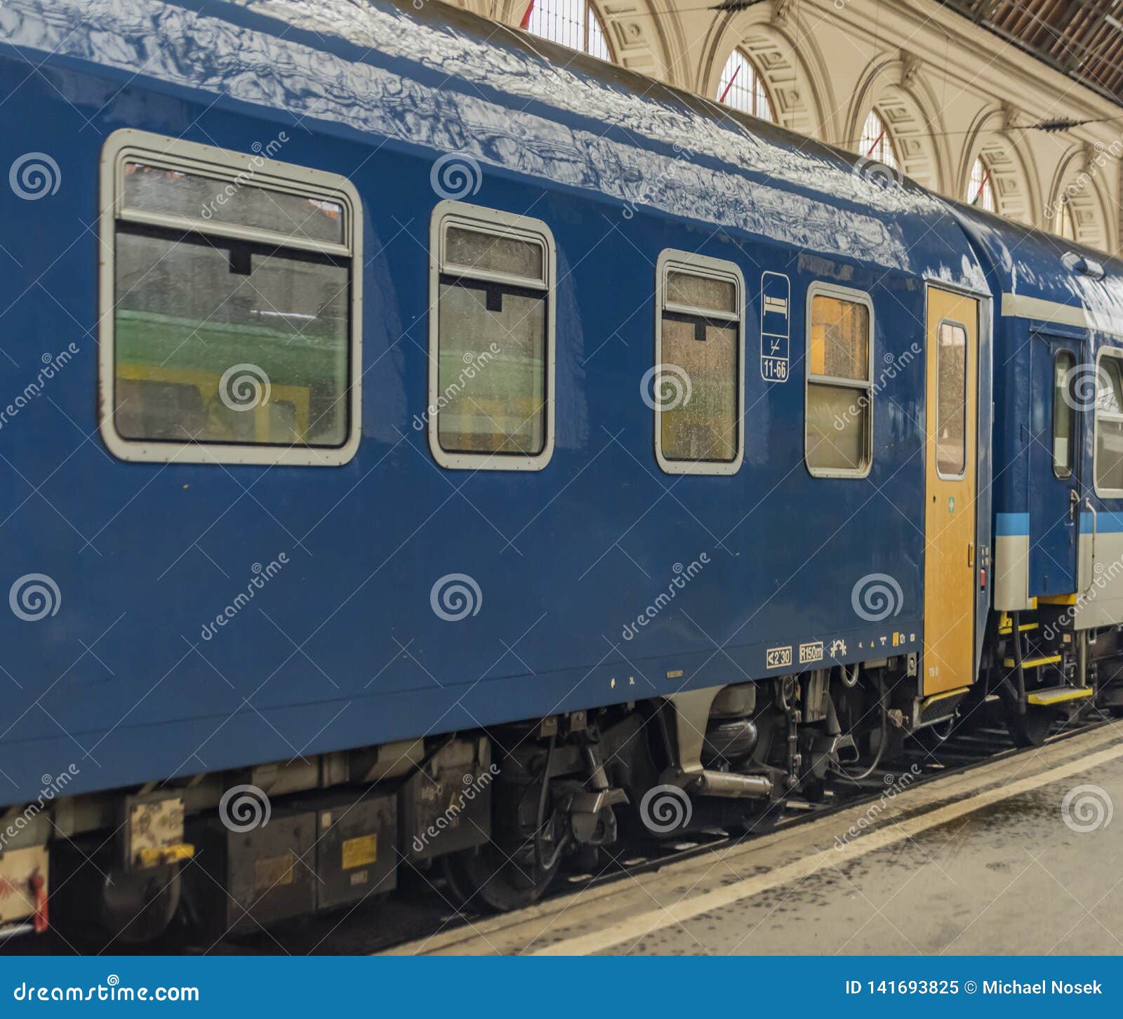 Treinador de sono azul com a porta amarela na estação de Budapest perto da plataforma