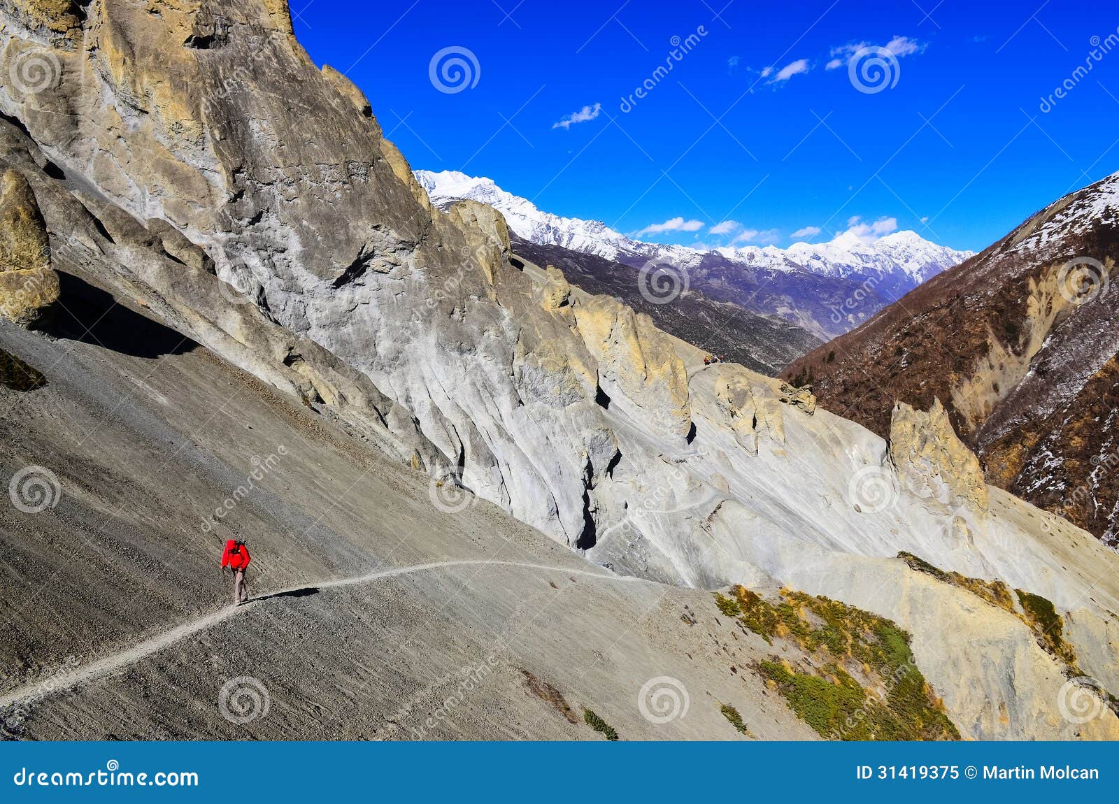 trekker in red jacket in himalayas mountains