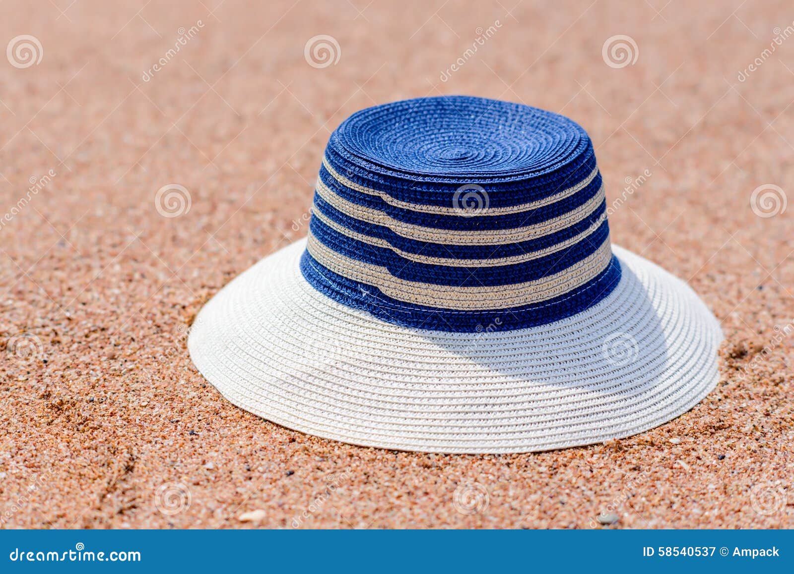 trendy sunhat lying on beach sand