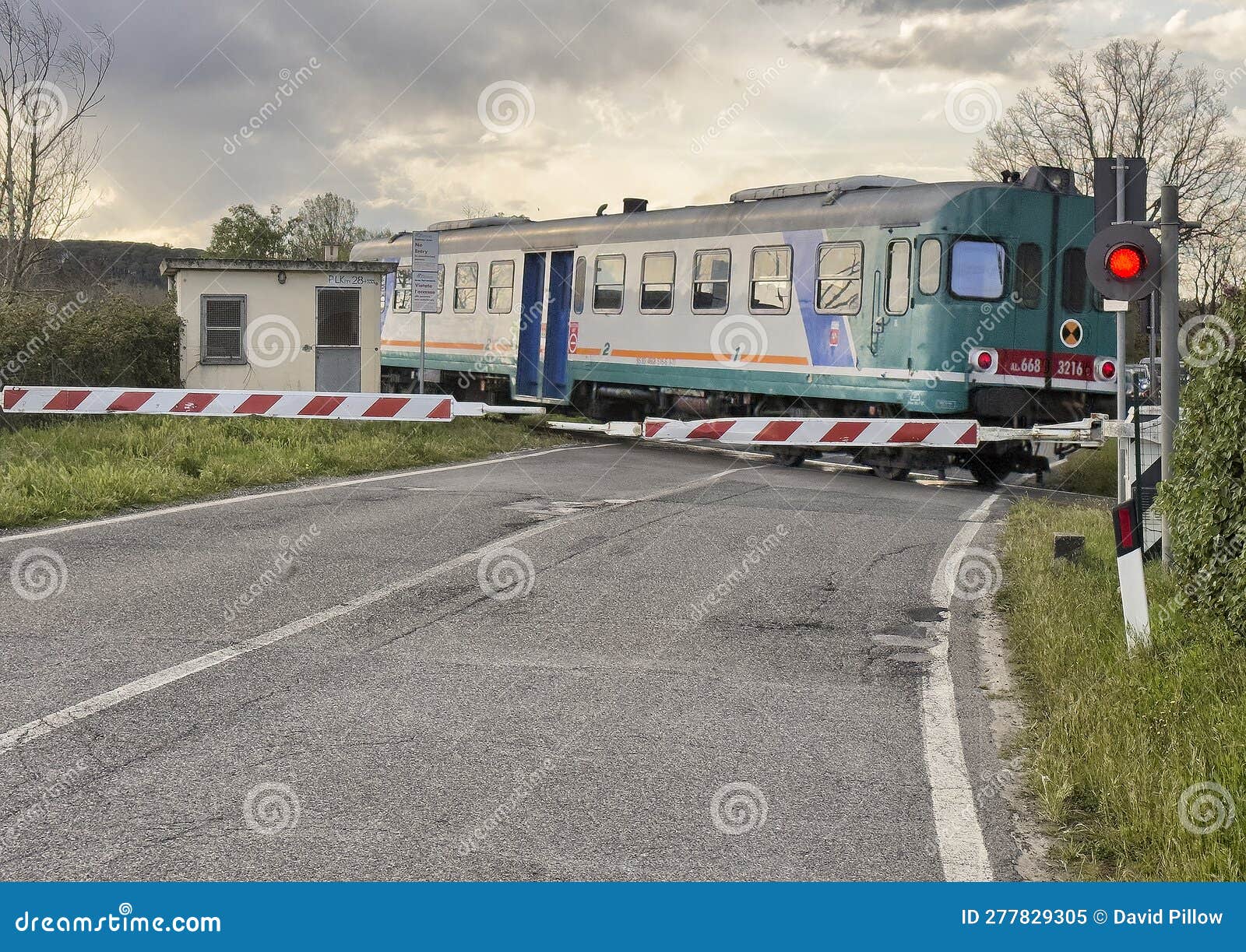 trenitalia diesel railcar aln 668 crossing a road in tuscany, italy.