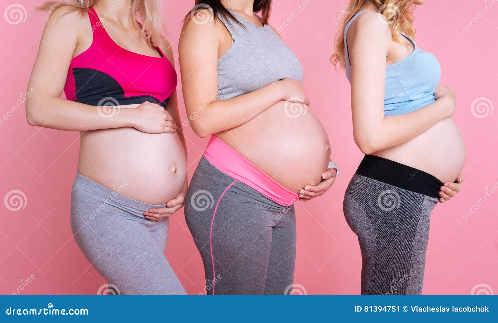 Una mujer embarazada proporciona cuidadosamente ropa para bebés