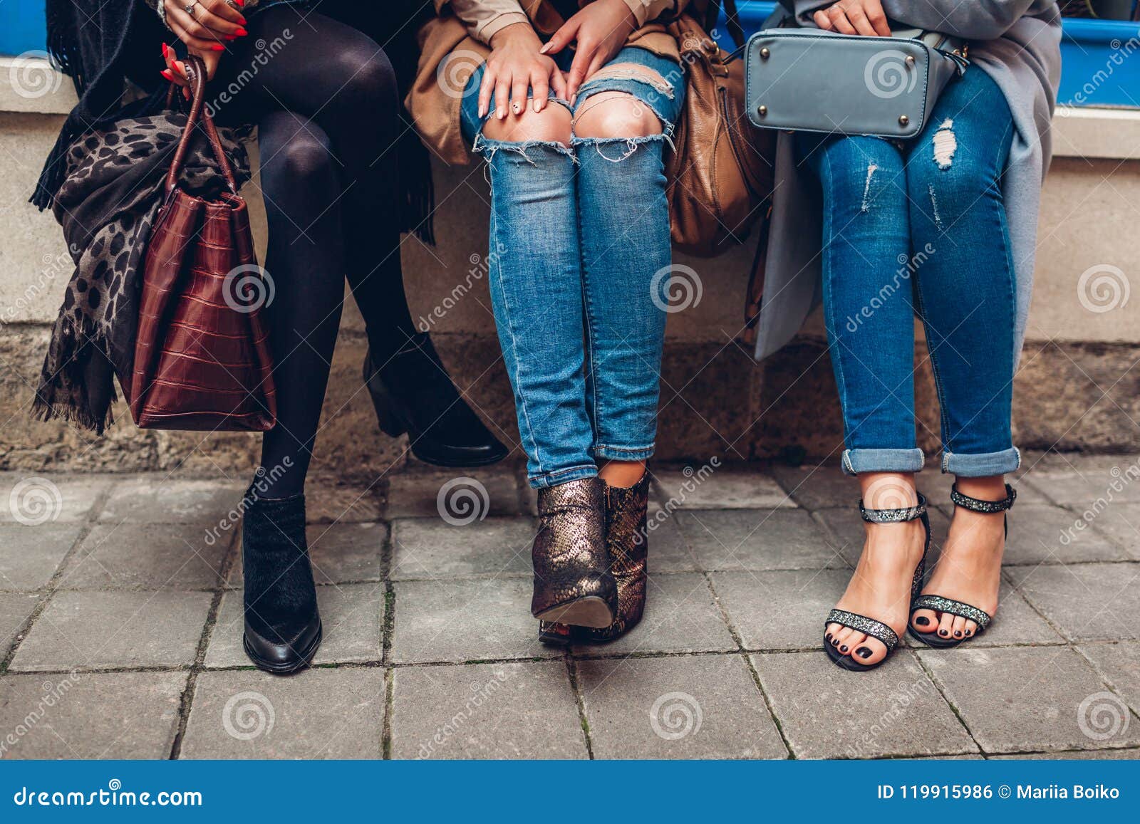 Tres mujeres que llevan los zapatos, la ropa y los accesorios elegantes al aire libre Concepto de la moda de la belleza