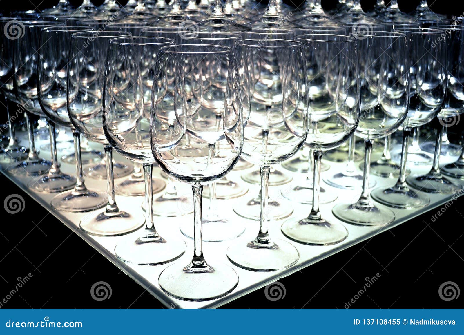 triangle of empty wine glasses rows for tasting arranged at a wine show.