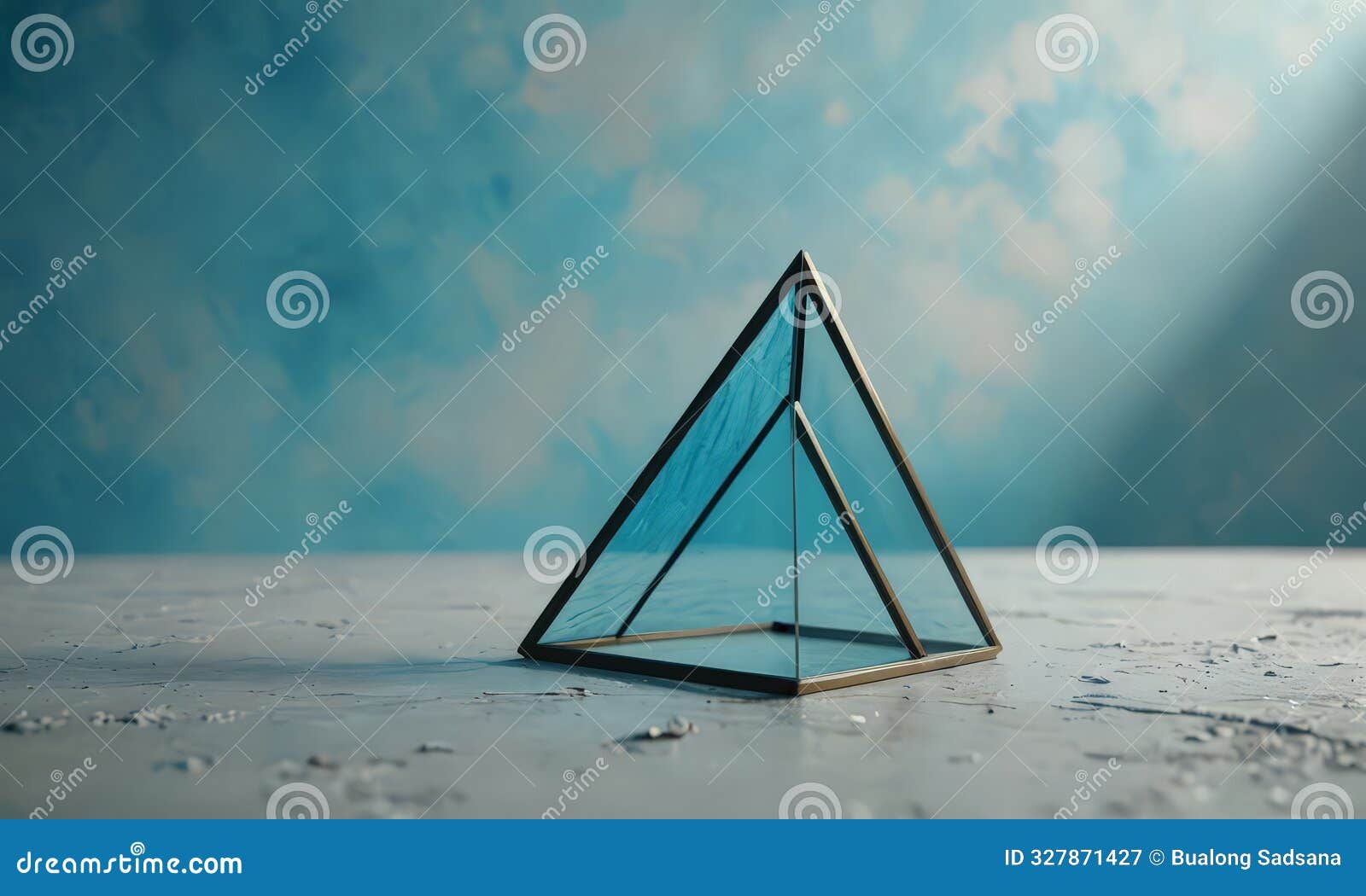 triangular glass sculpture with pointed top stands on white surface, casting shadow and contrasting with the
