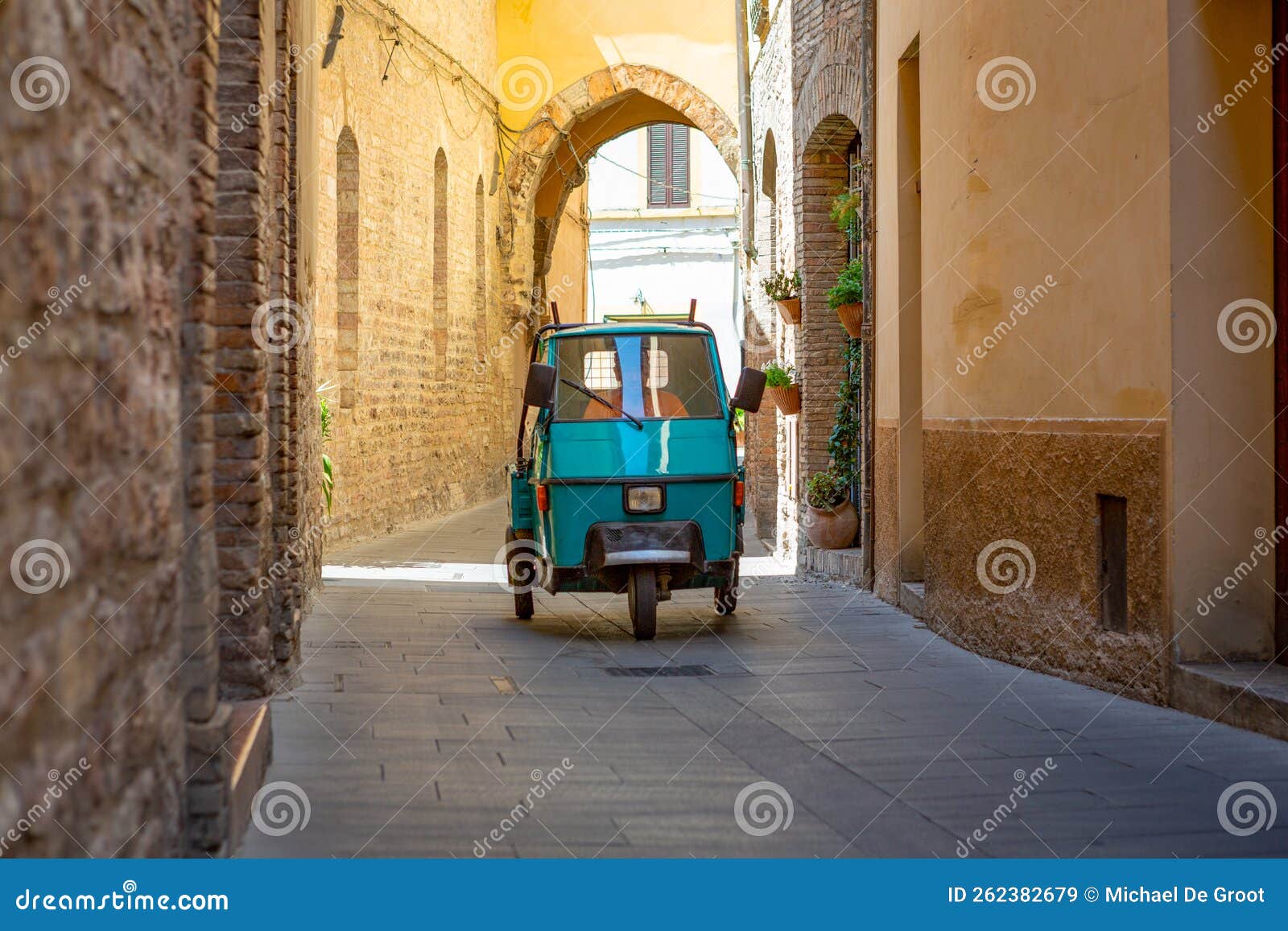 tricycle driving in an empty street in spello