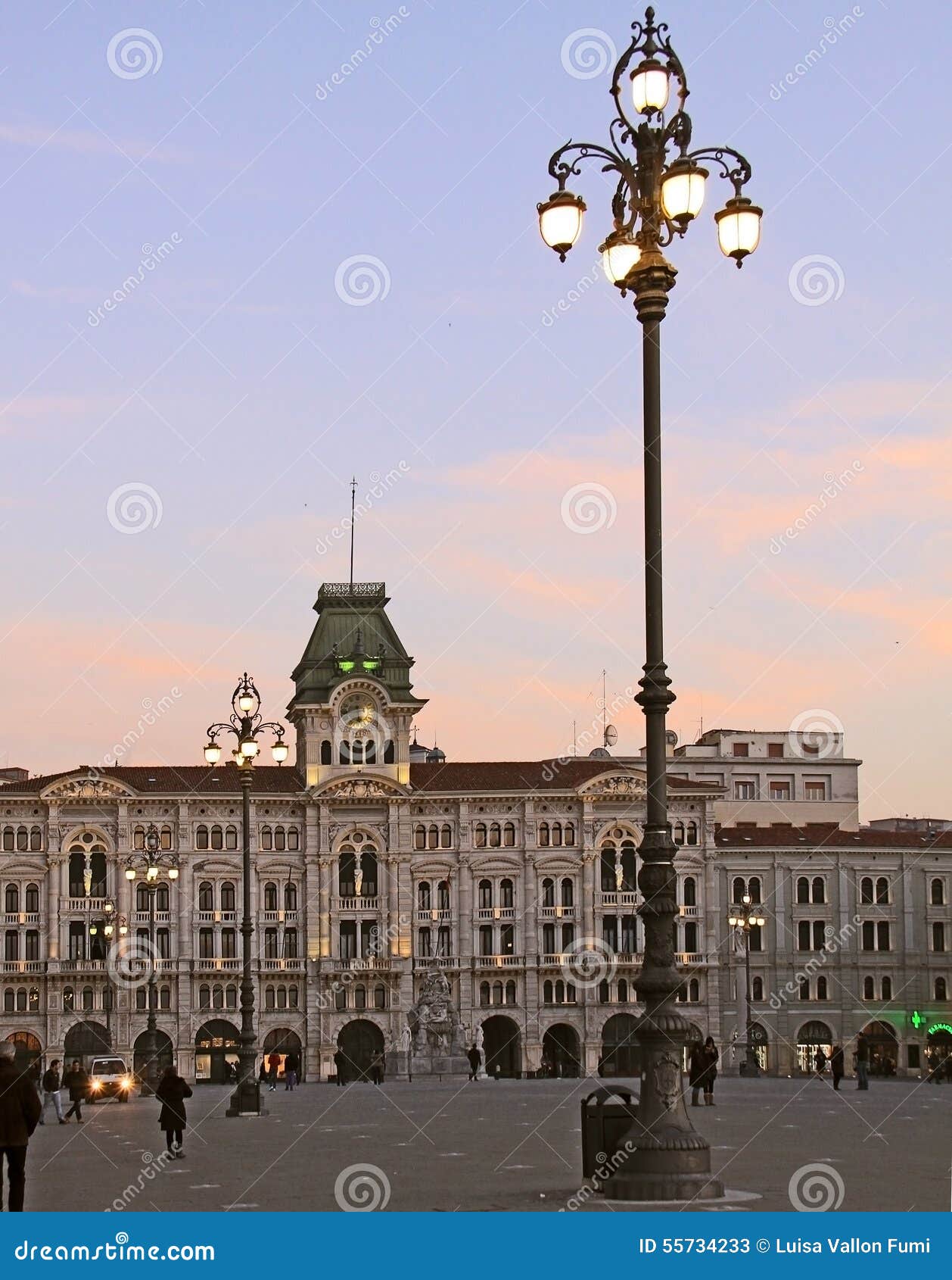 Trieste, Italy - Citi Hall in Union of Italy square at twilight. Trieste, Italy - Union of Italy square at twilight with lit street lamps and the view of city s municipal building