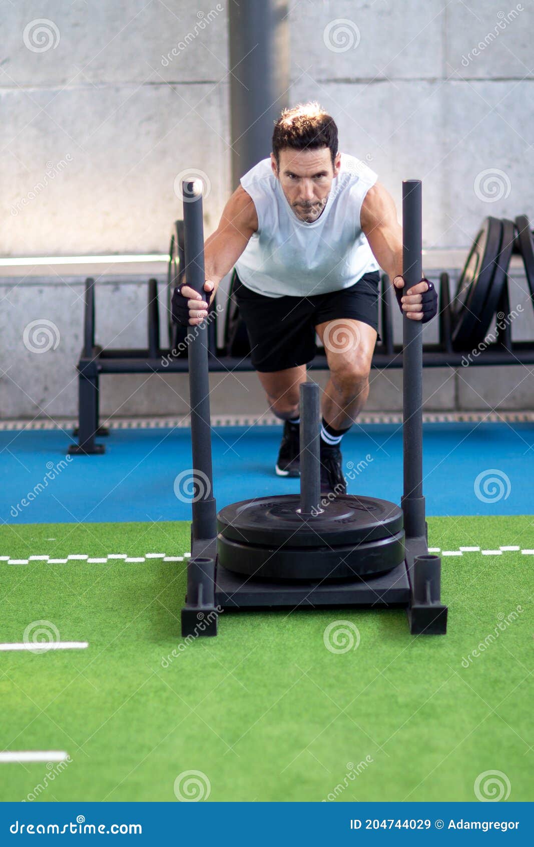 Empujar el trineo de Crossfit hombre empujando pesos ejercicio de  entrenamiento Fotografía de stock - Alamy