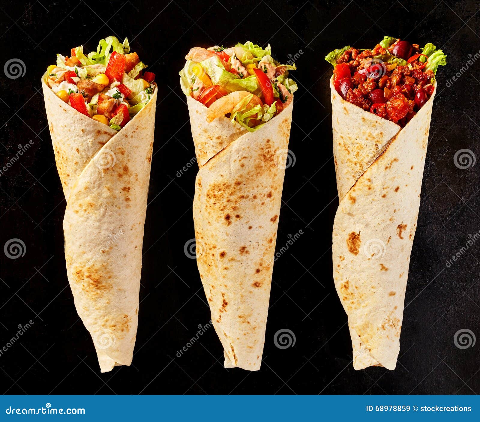 trio of tex mex fajita wraps on black background