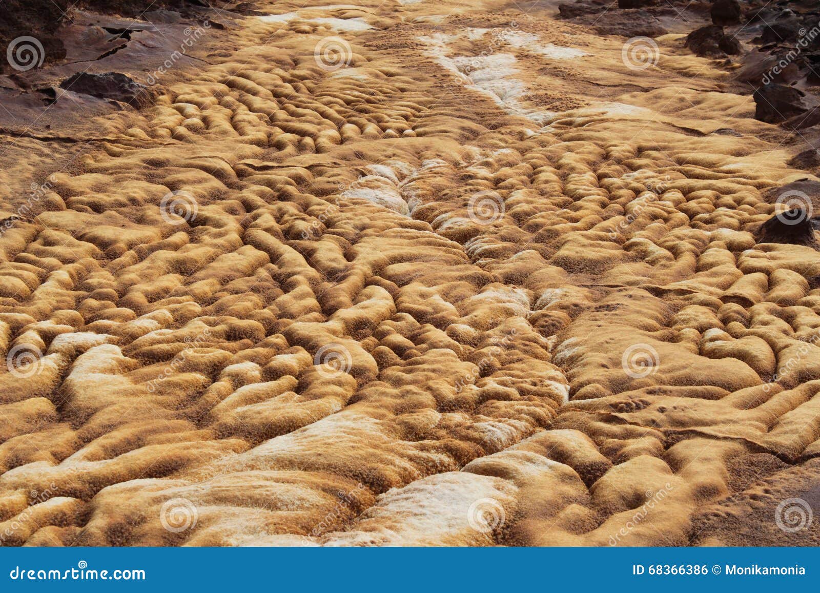 Trockene Mineralstraße. Der trockene Fluss, der mit bunten Mineralien, Gold, Weiß, Rot, braune Oberfläche der Unterseite des Flusses, Ort des Bergbaus bedeckt wird, Fluss sieht wie eine Vulkanlava aus