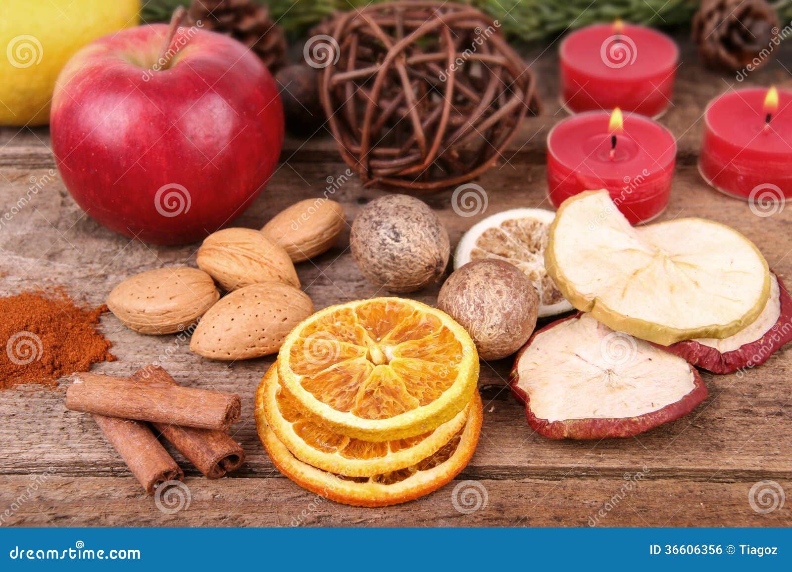 Trockenfrüchte mit Nüssen und Kerzen. Weihnachtsstimmung mit Trockenfrüchten, Nüssen und Kerzen auf einem rustikalen Holztisch