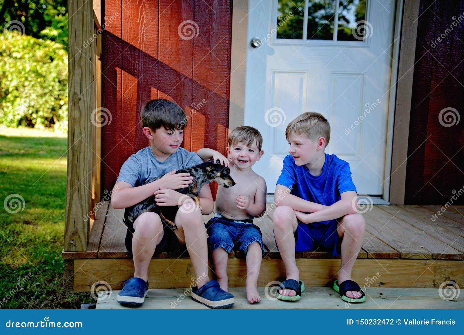 Trois frères avec le chien. Le jeune frère trois s'est assis sur des étapes de cabine avec le chien de chiweenie d'animal familier