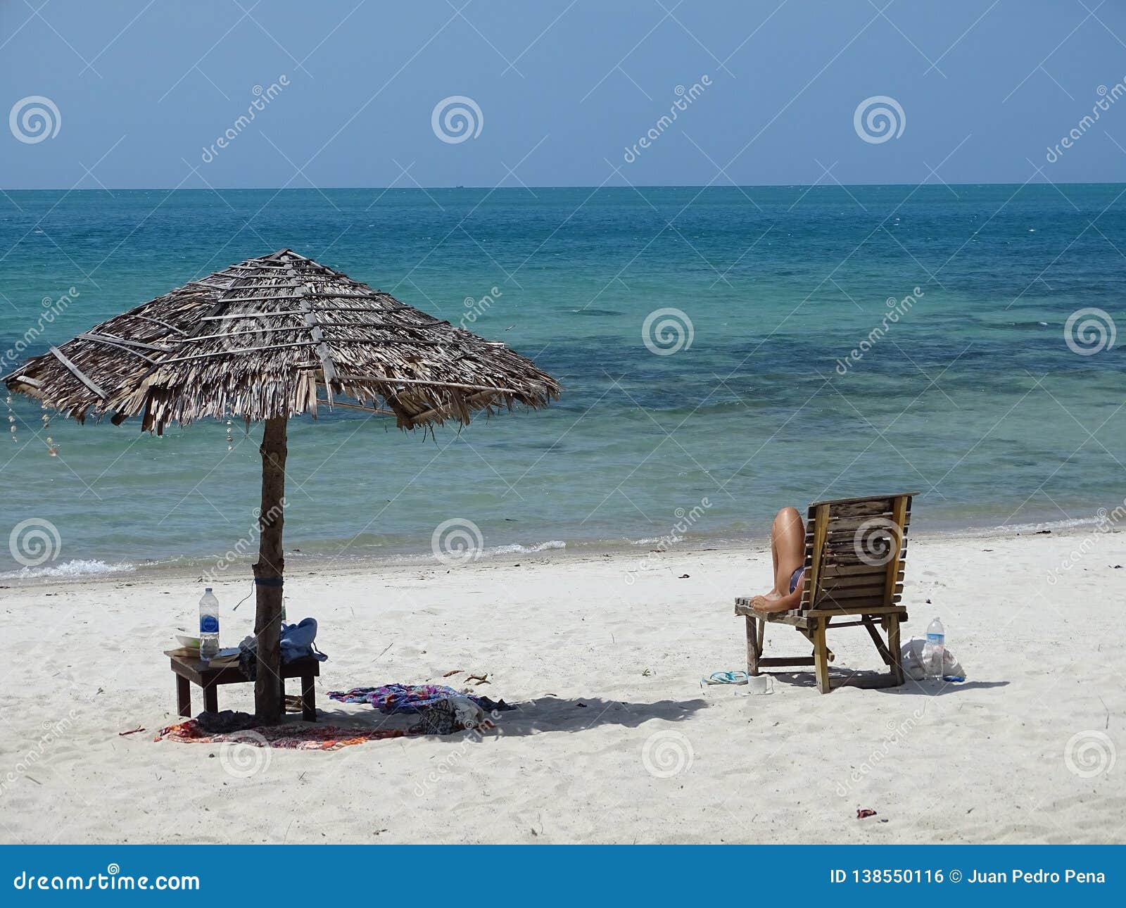 tropical beach with white sand, blue water and parasol