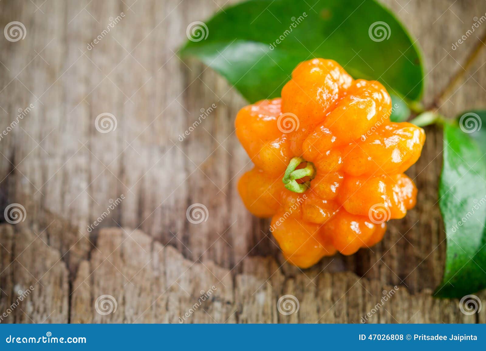 Tropical fruit also called Pitanga, Brazilian Cherry, Suriname Cherry, Cayenne Cherry on wooden background.