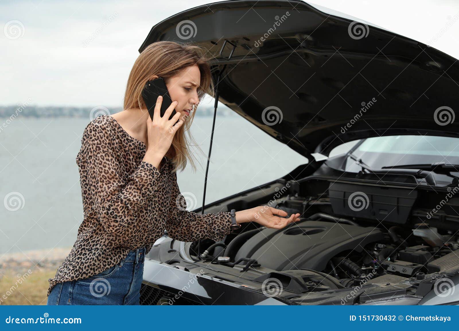 Troubled Young Woman Talking On Phone Near Broken Car Stock Phot