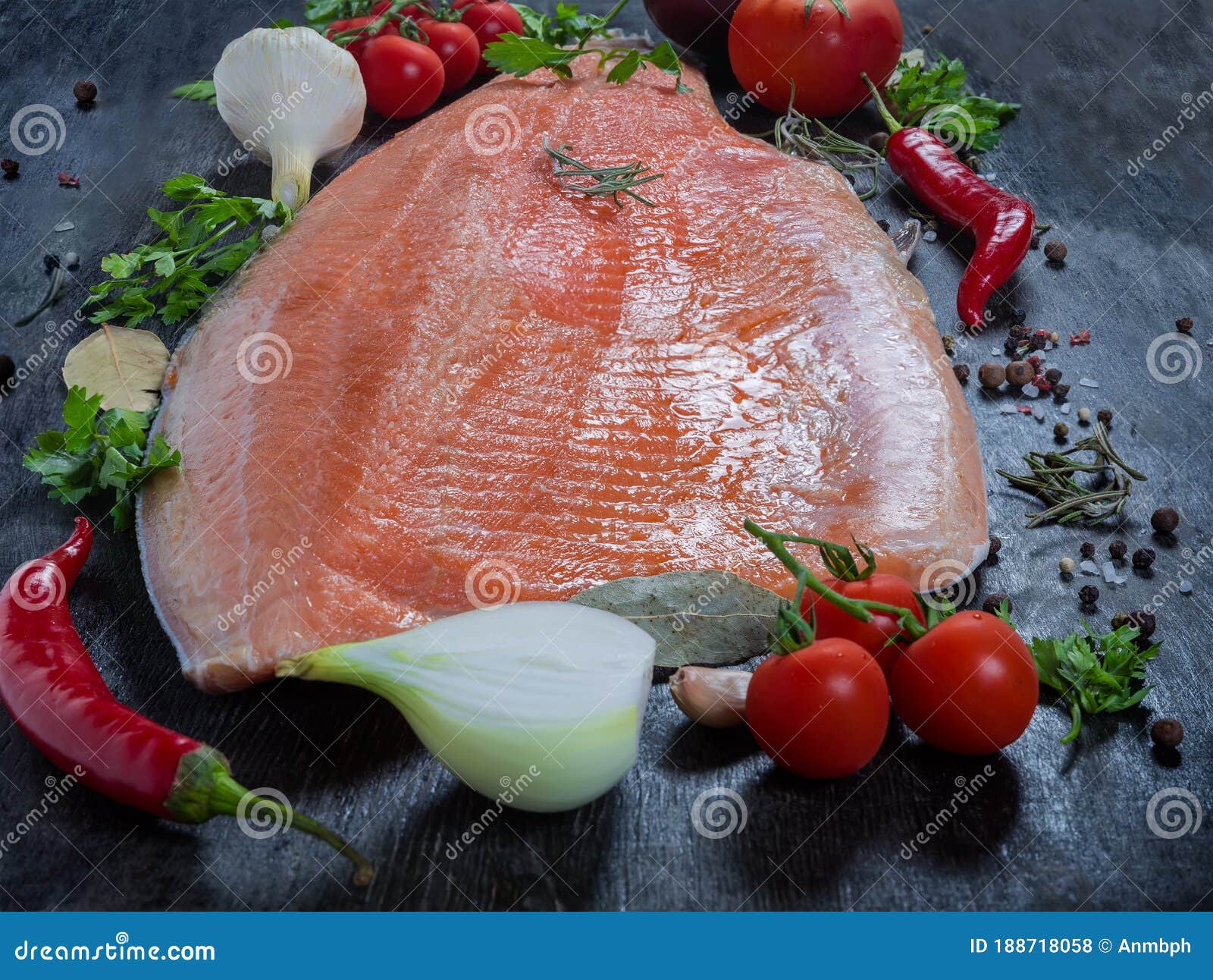 trout fillet among vegetables and spices closeup in selective focus