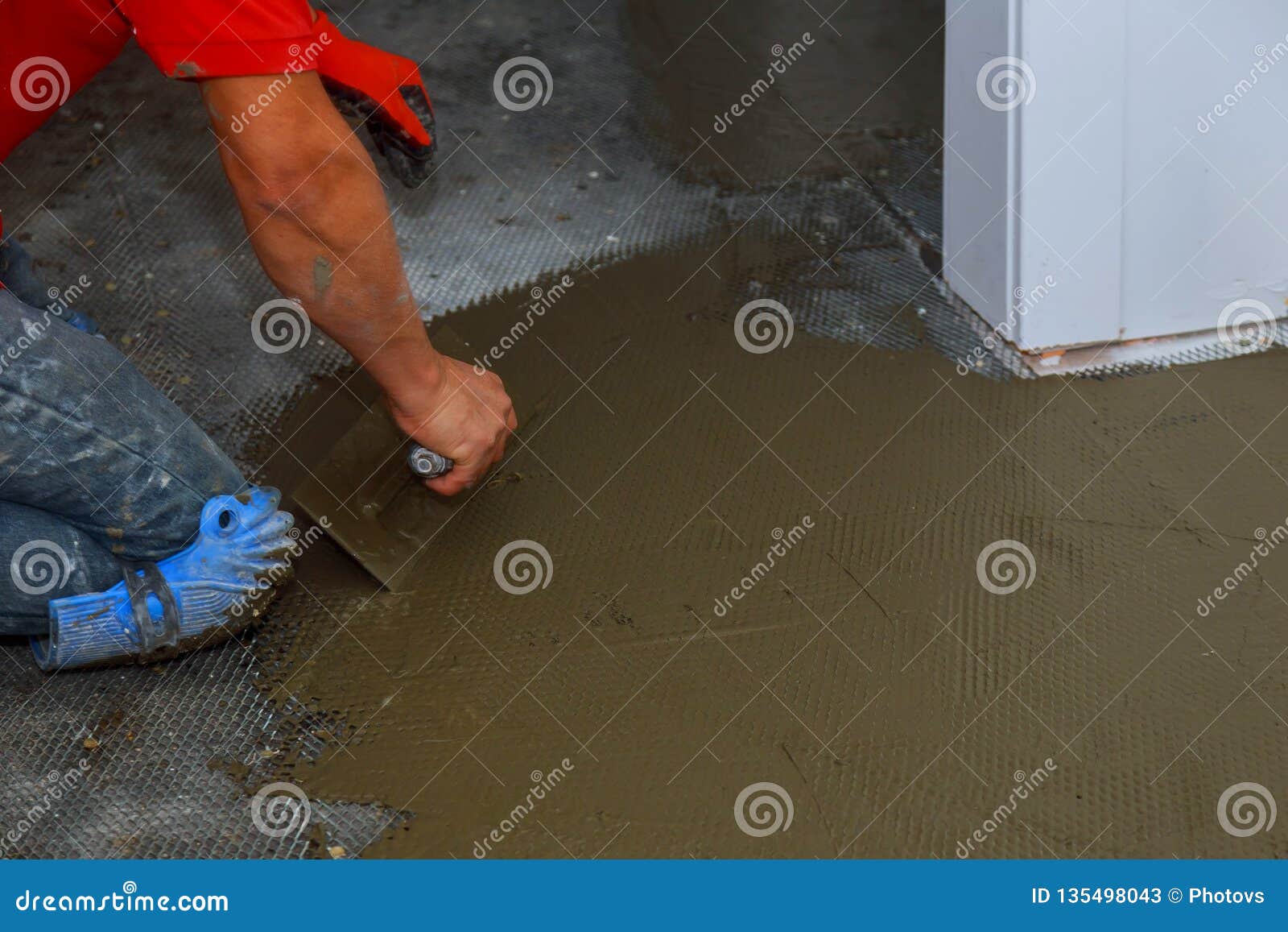 Troweling Mortar Onto A Concrete Floor In Preparation For Floor