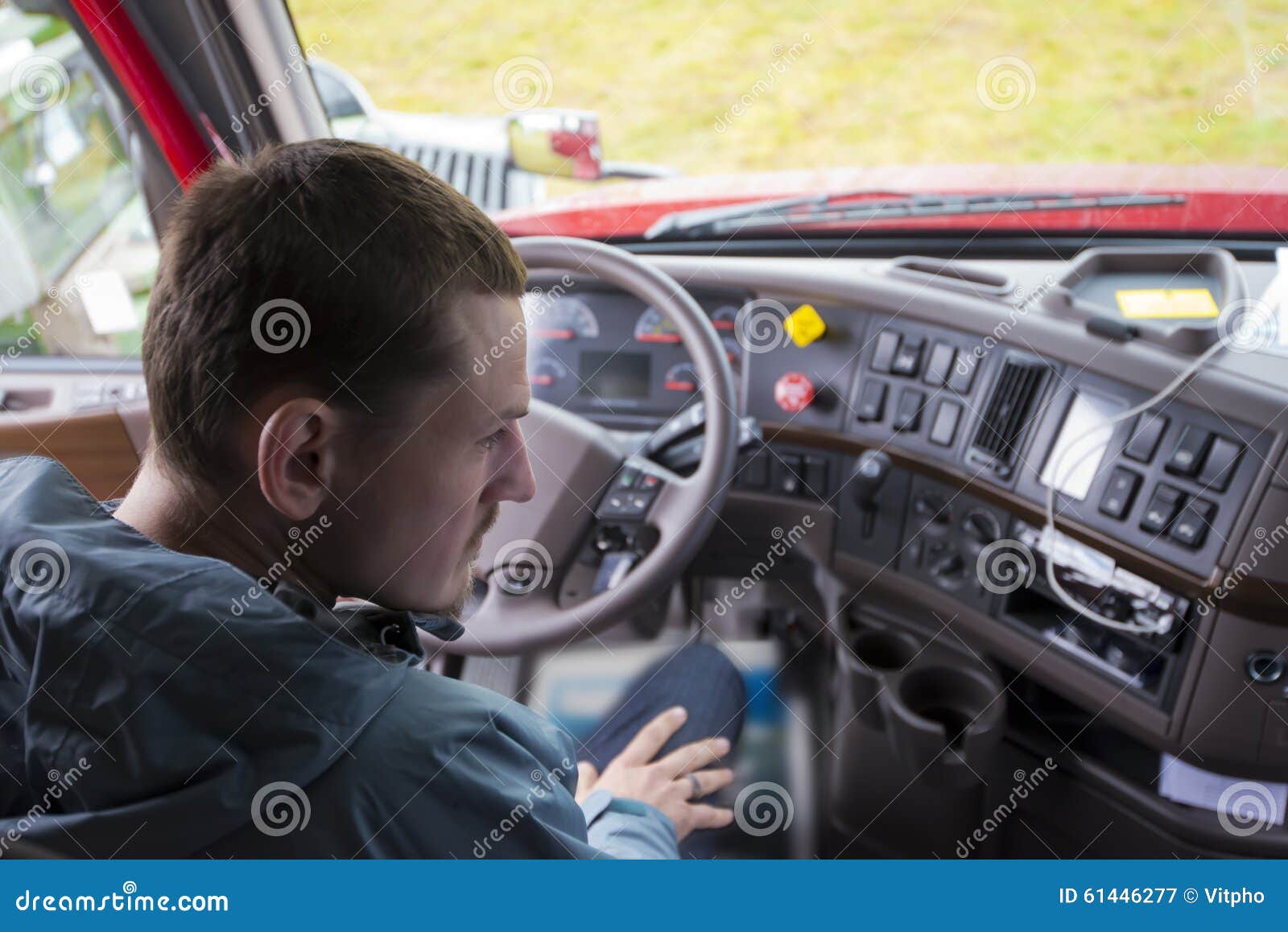 truck driver in semi truck cab with modern dashboard