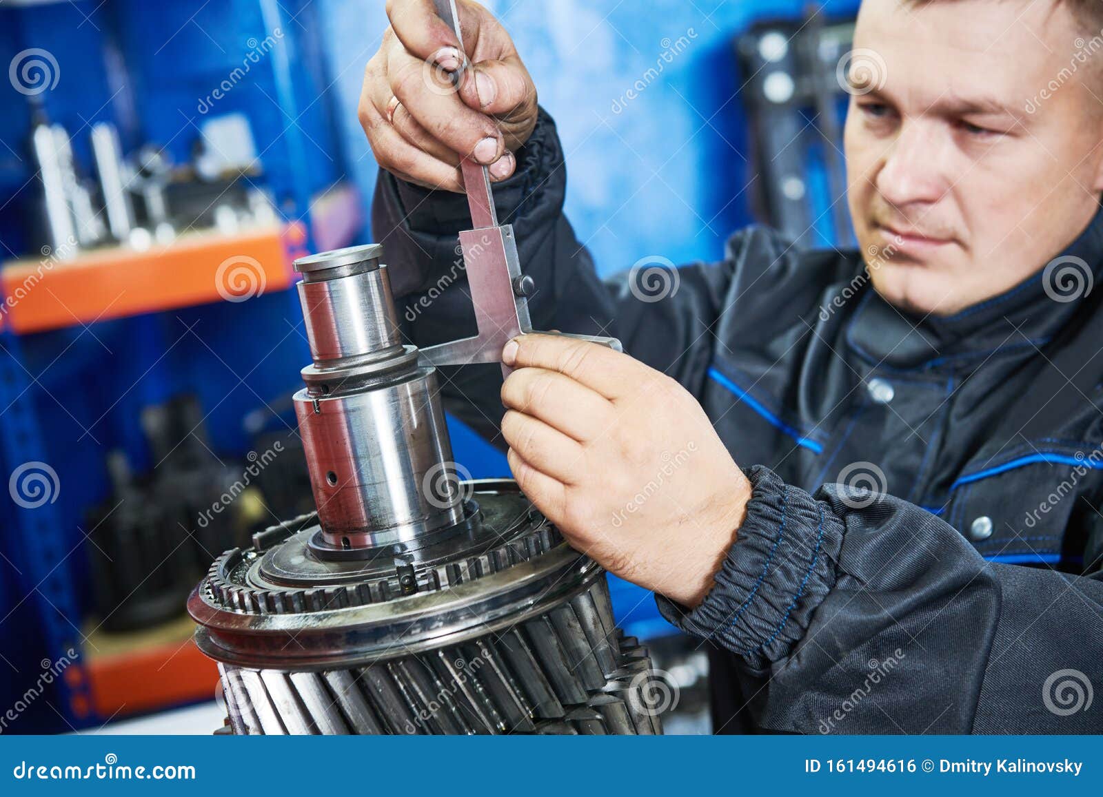 truck repair service. serviceman measuring gear shaft of gearbox