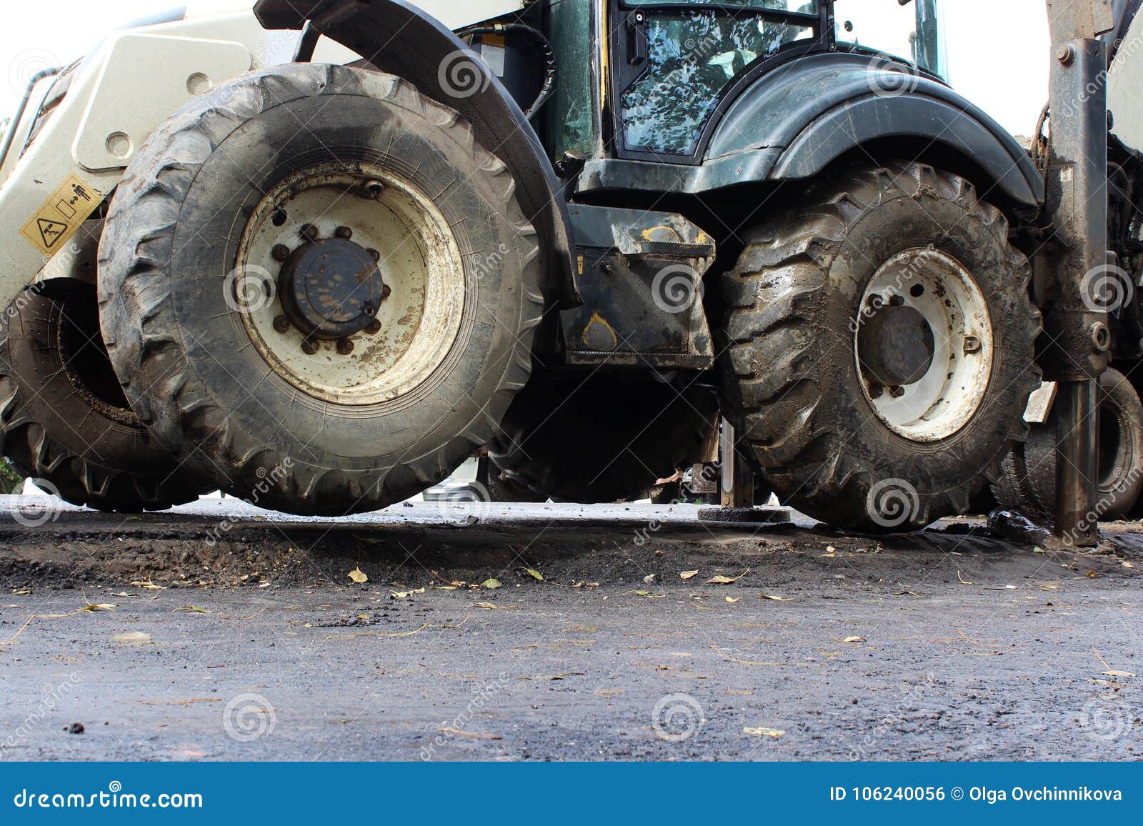 truck strong outrigger stabilizing legs extended. tractor on extended outriggers for better stability, digging a bucket