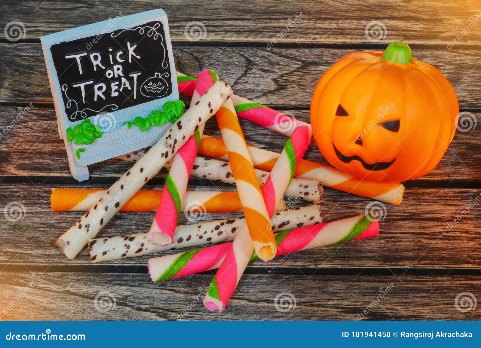 Truco o invitación, calabaza de la decoración de Halloween de la Jack-o-linterna con bocado del caramelo en fondo de madera