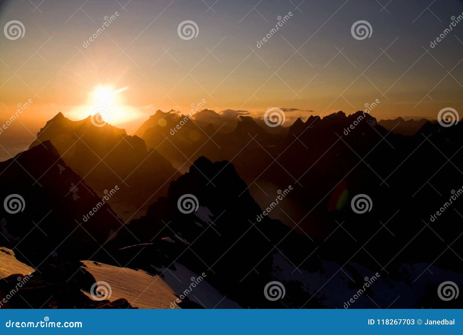 true lofoten midnight sun over sharp mountains of moskenesoya and fjords, seen from munken peak summit, norway
