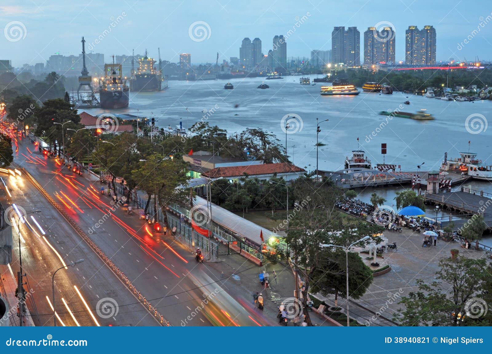 Tráfico de la última hora de la tarde en Ho Chi Minh City. Ho Chi Minh City, Vietnam - 7 de junio de 2011: El río de Saigon en la última hora de la tarde. En el primero plano el hogar de la precipitación de las motocicletas y de los coches a lo largo de la calle de Ton Duc Thang en una tarde mojada.