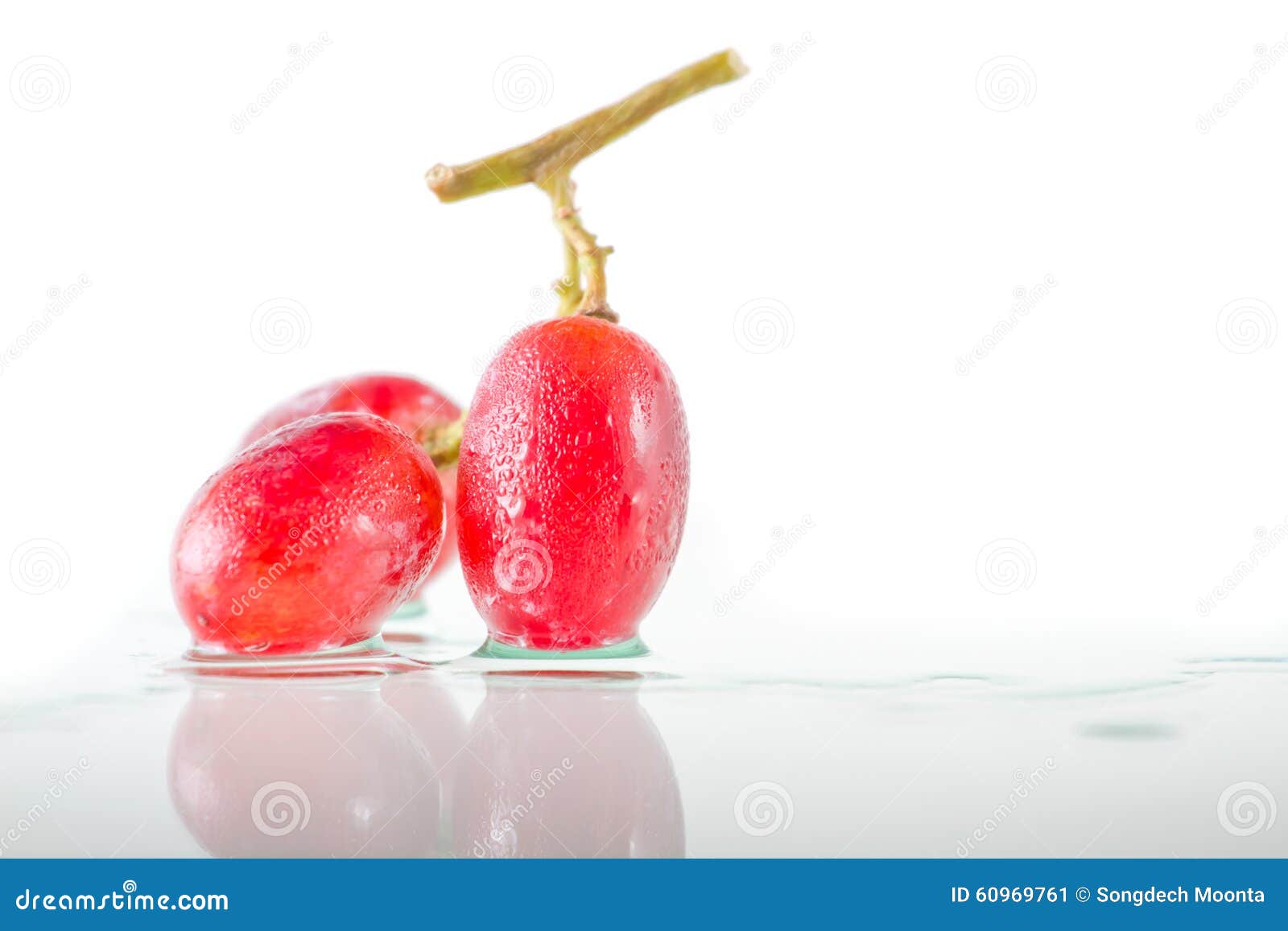 Três de uvas vermelhas fecham-se acima, isolado em um fundo branco