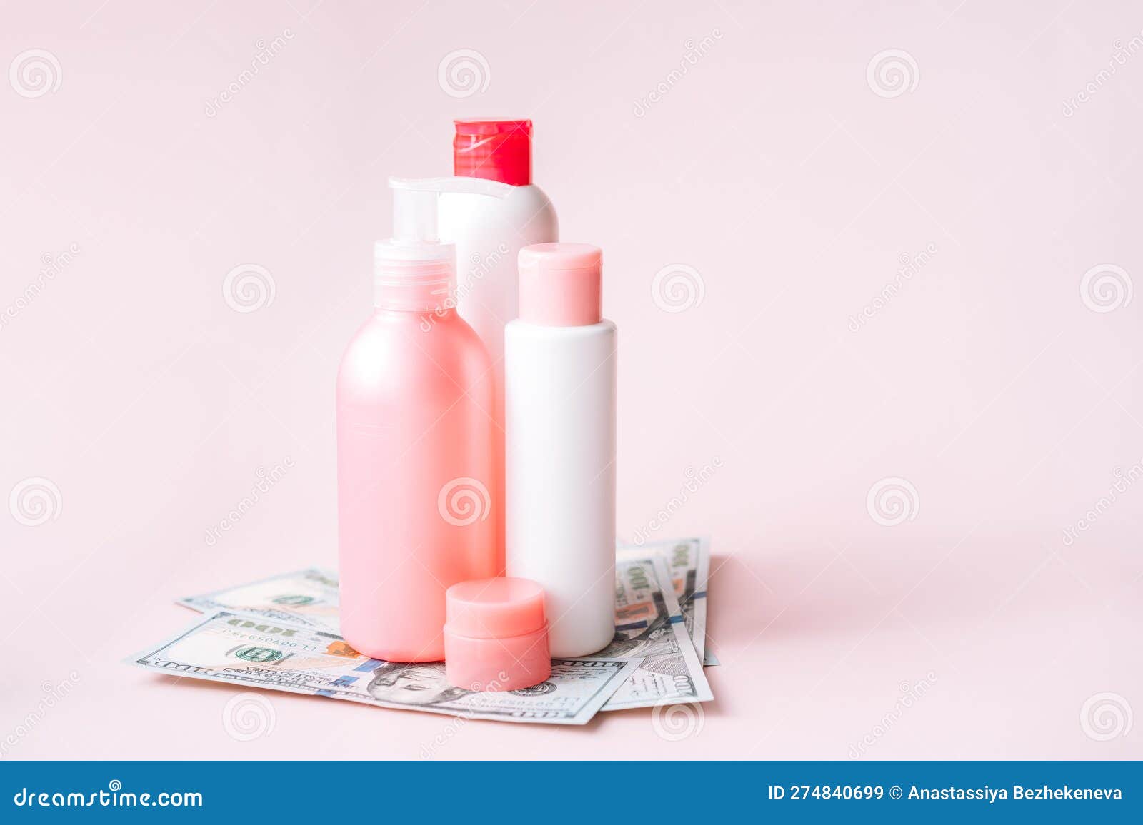 tubes with hygiene products on dollar bills against pink background