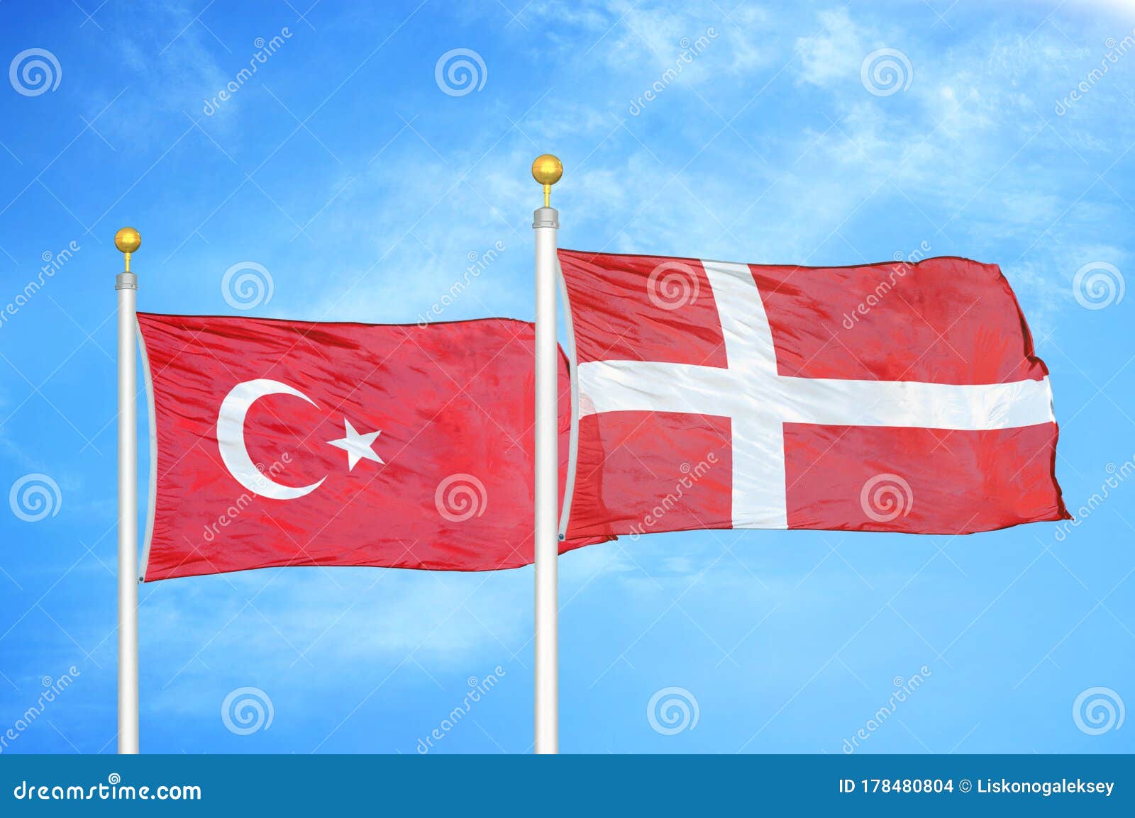 Turkey and Denmark Two Flags on Flagpoles and Blue Cloudy Sky Stock