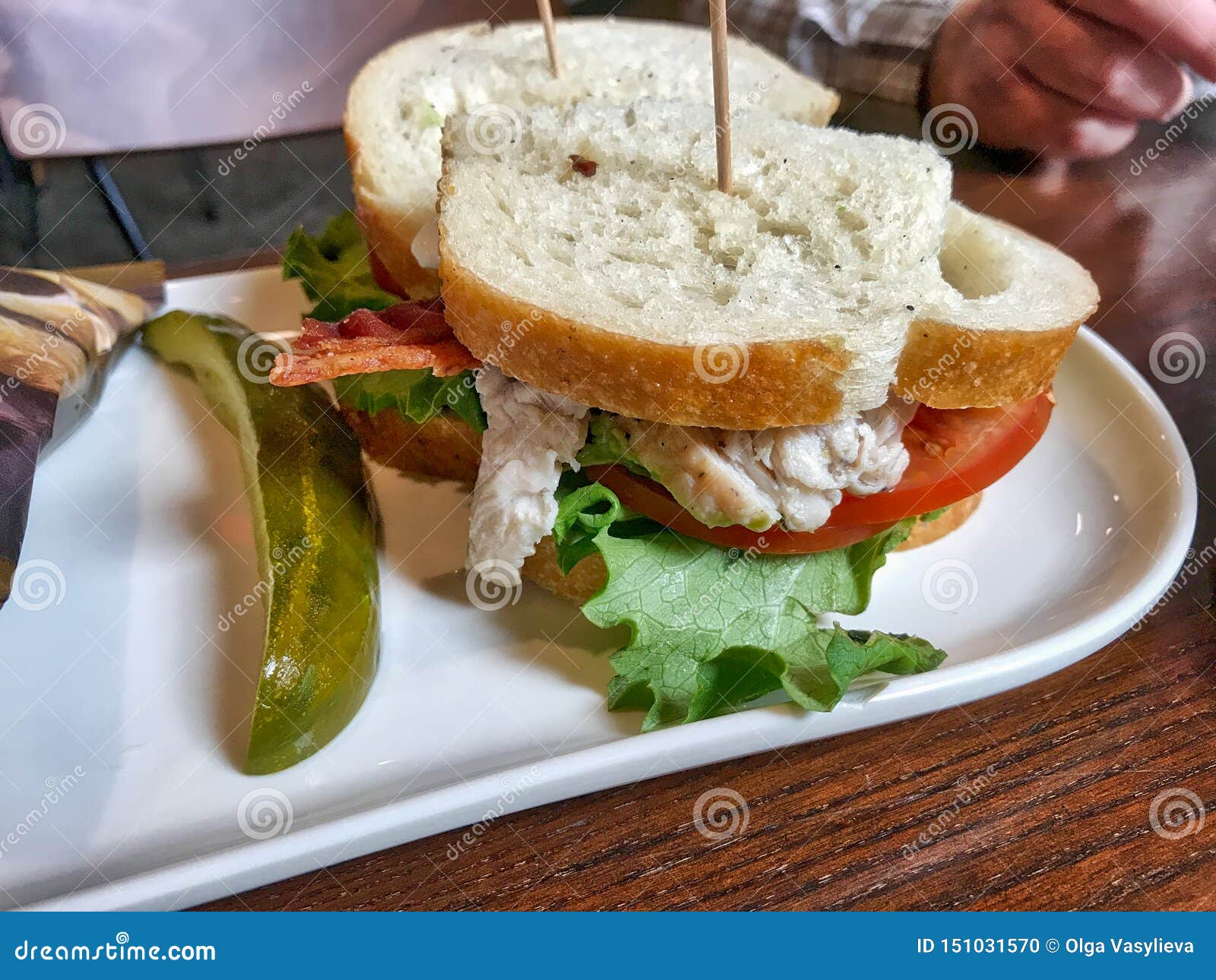 turkey sandwich with tomato, pickle and lettuce