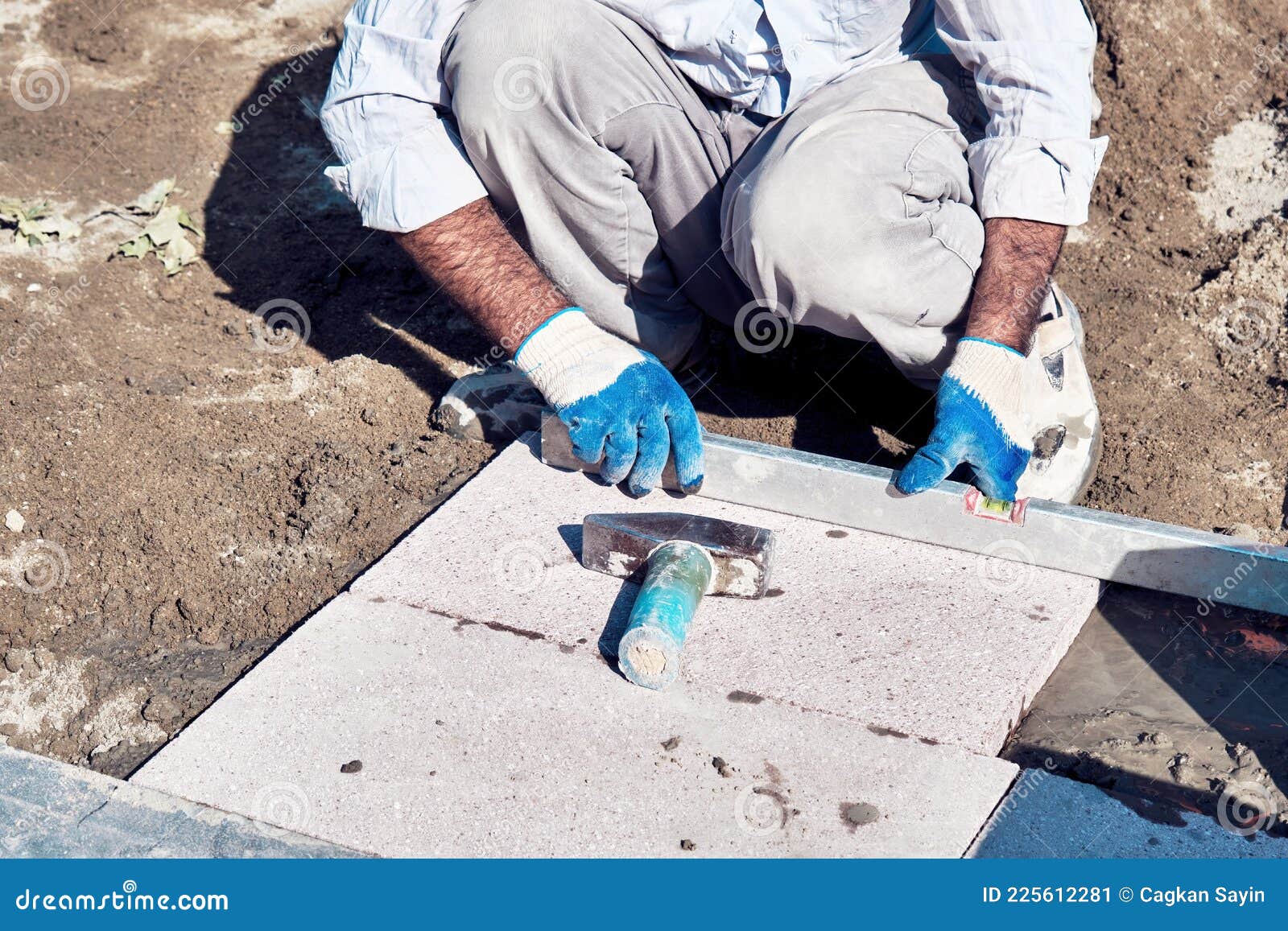 Pavement Construction Worker Using a Water Level Tool for Balancing the Tiles Stock Image