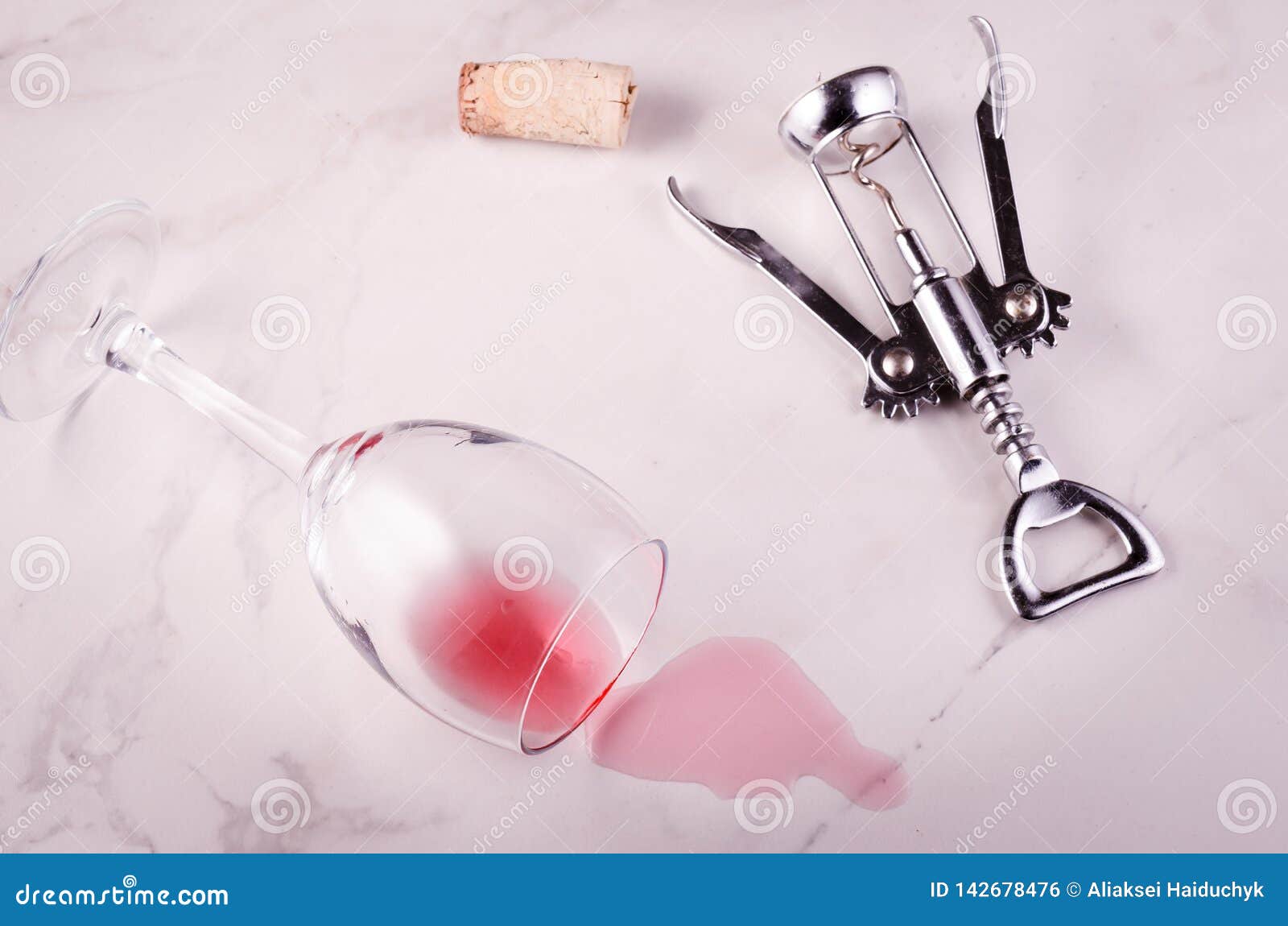 Turned Wine Glass and Corkscrew on Marble Background/turned Red Wine