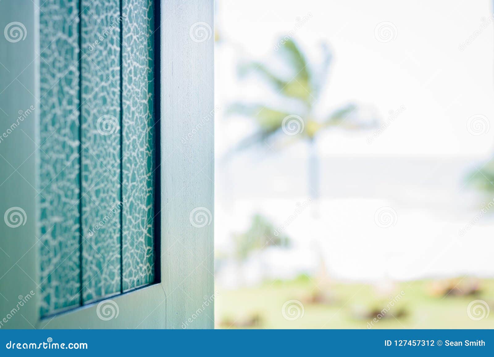 turqoiuse painted window shutter overlooking the ocean