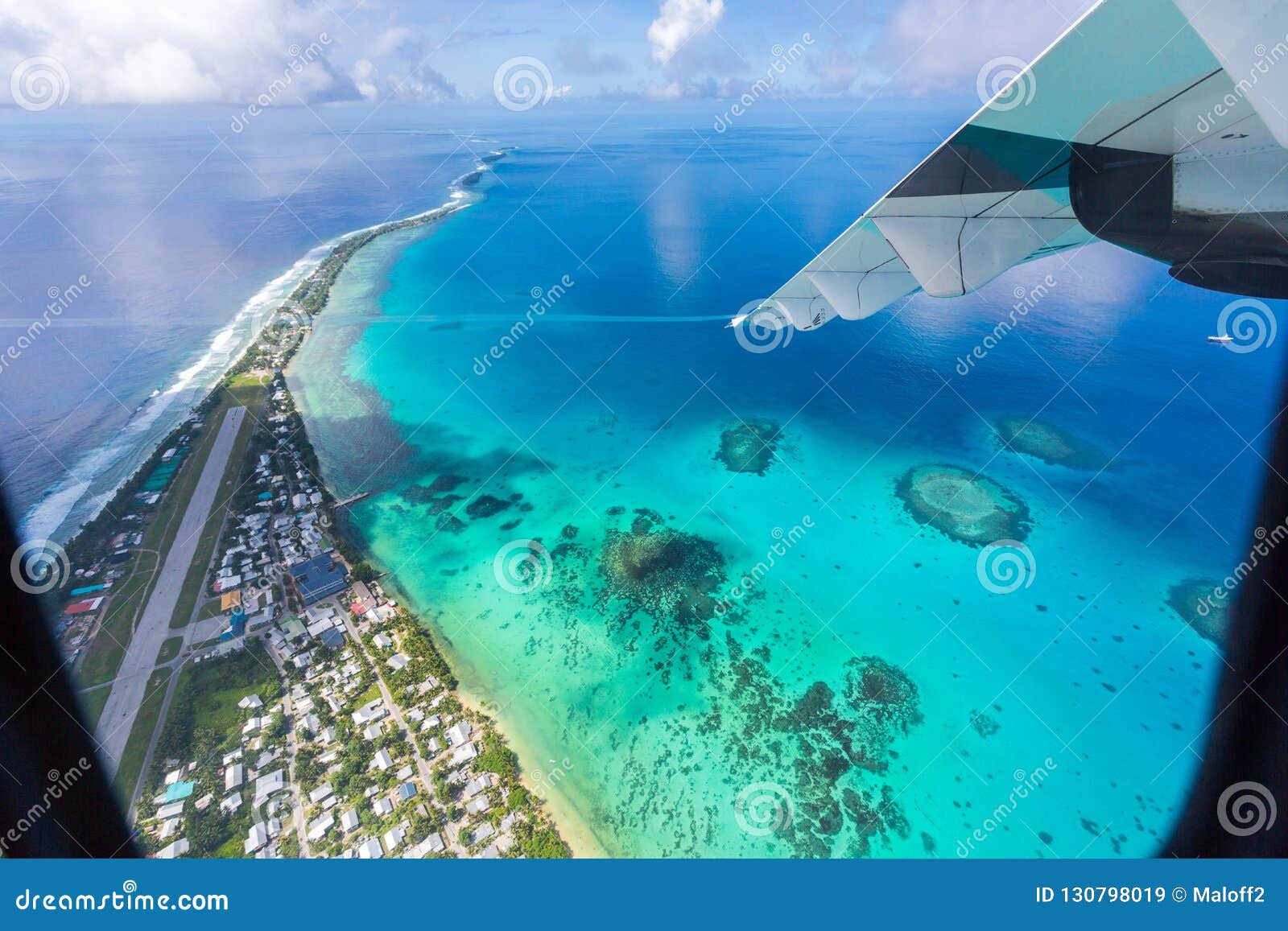 tuvalu island azure turquoise blue lagoon under the wing of an airplane, aerial view. polynesia, oceania.