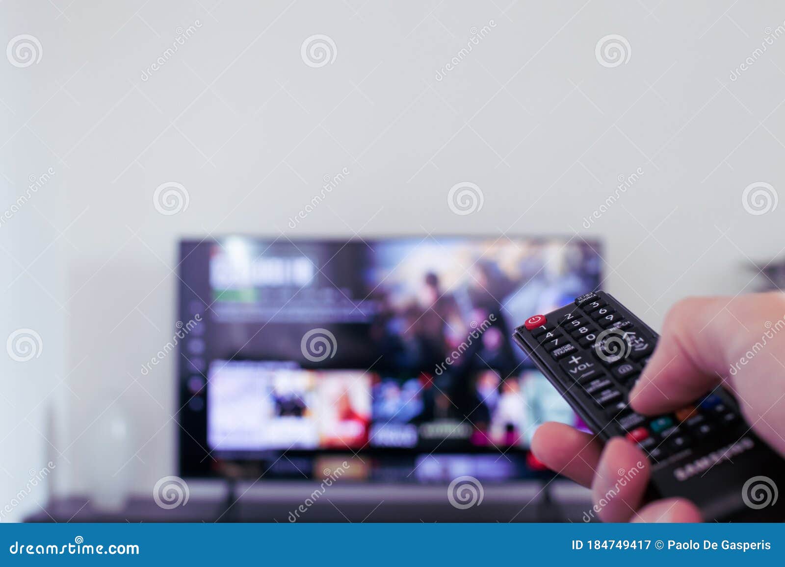 tv remote controller in hand of customer looking for some content in smart tv app for streaming video. watching streaming services