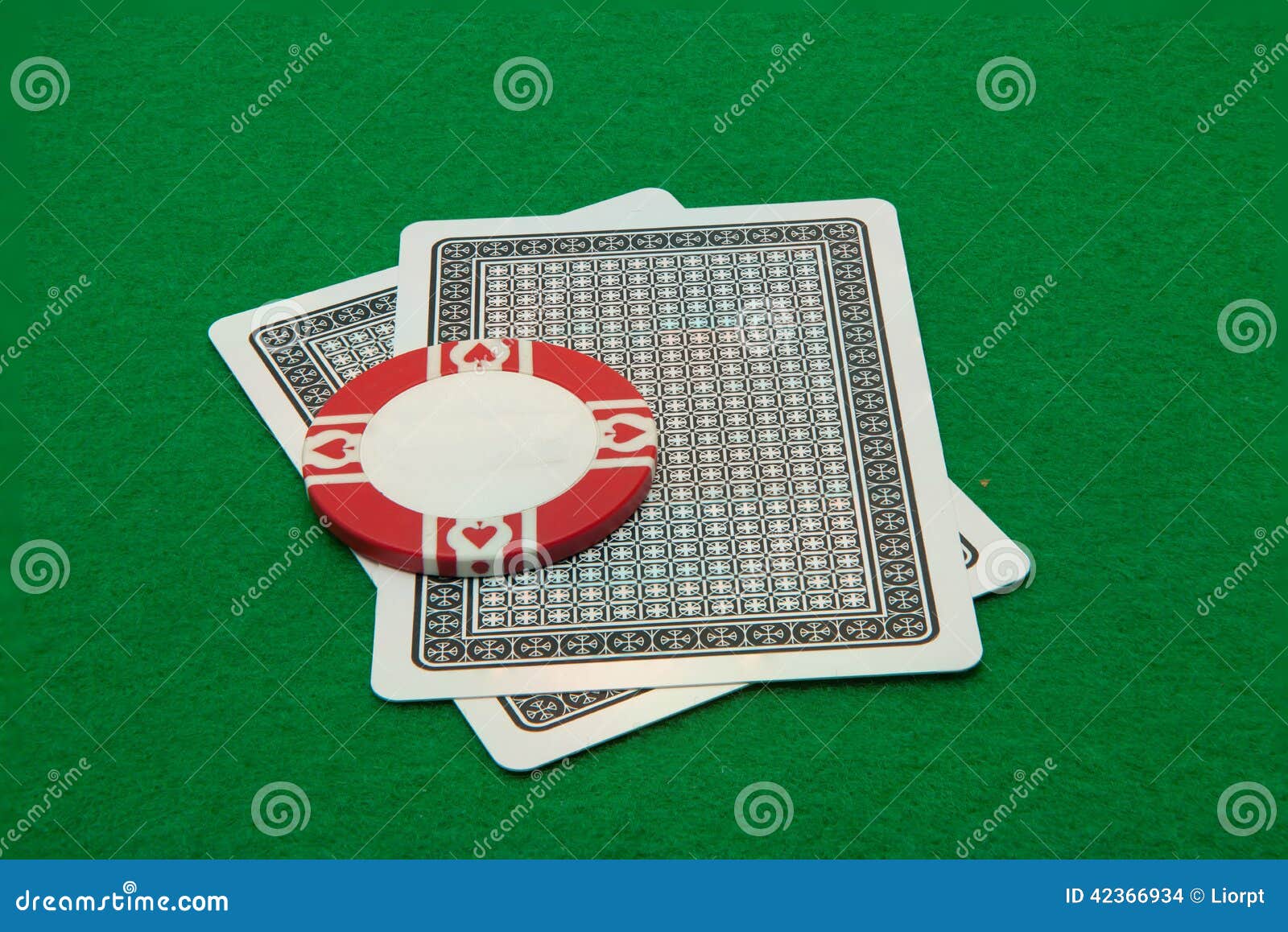 Två kort som ner vänder mot med kasinochipen på gräsplan. Två kort som ner vänder mot med kasinochipen på grön bakgrund