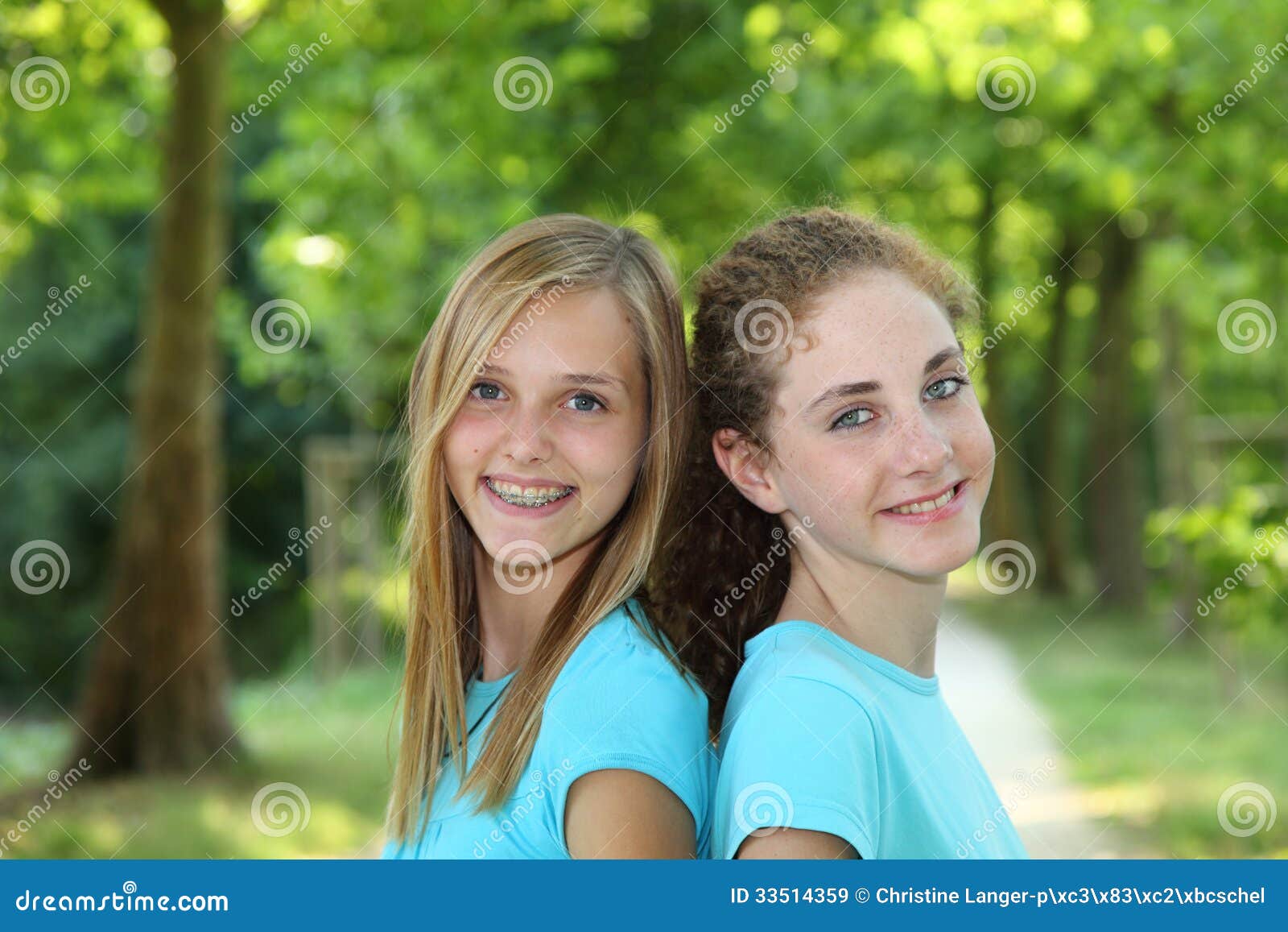 Twee Gelukkige Tieners Die Zich In Een Park Verenigen Stock Afbeelding