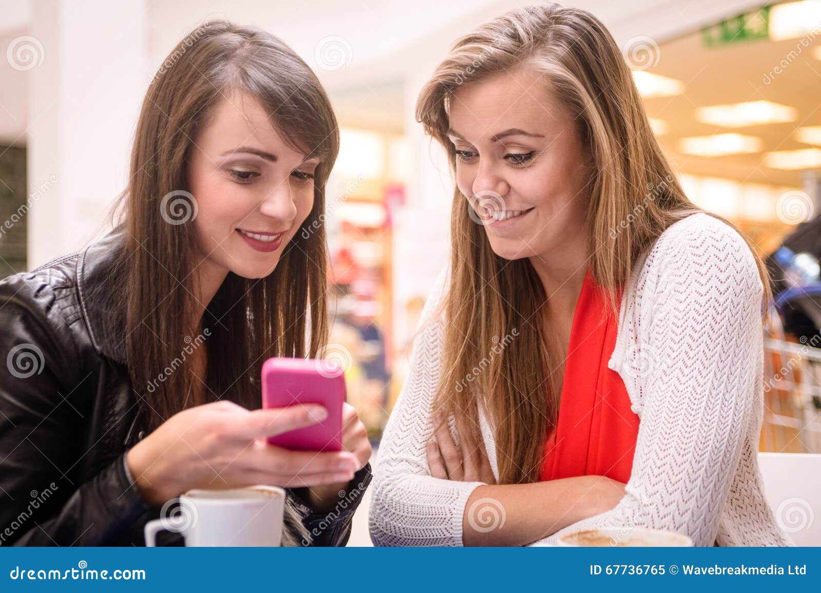 Twee Vrouwen Die Mobiele Telefoon Bekijken Stock Afbeelding - Image of ...