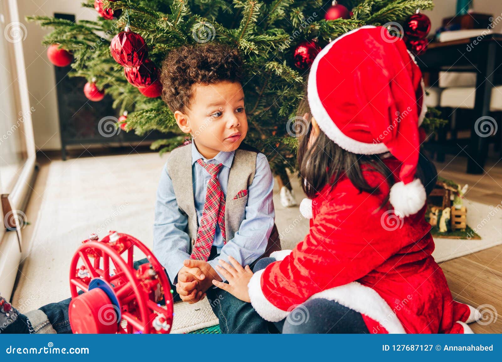 Two Adorable 3 Year Old Kids Playing by the Christmas Tree Stock Image