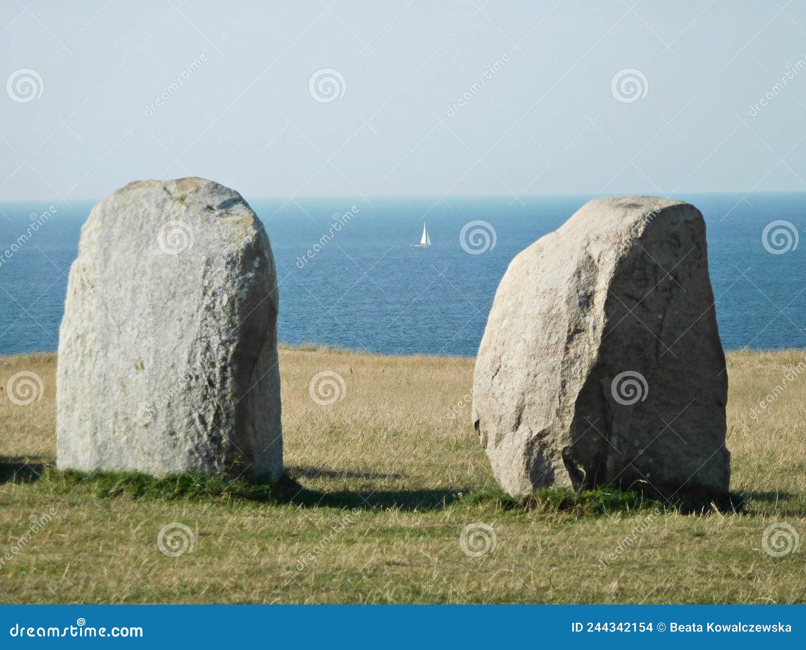 two ales stenar boulders and a white sailboat, sweden